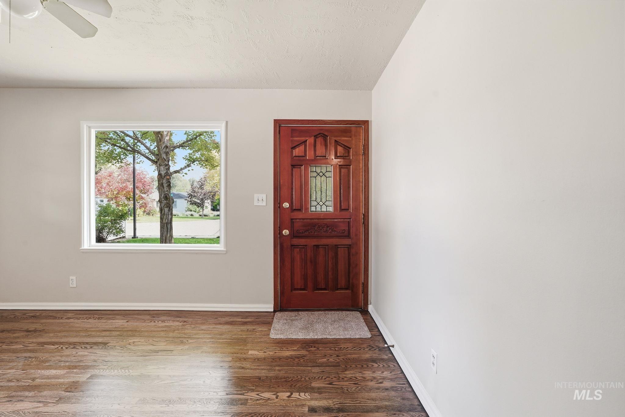 Entrance foyer with wood finished floors, a textured ceiling, and ceiling fan
