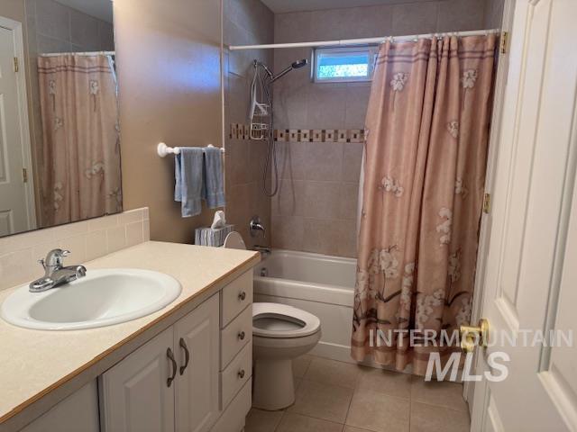 Full bath featuring vanity, light tile patterned flooring, and shower / tub combo with curtain