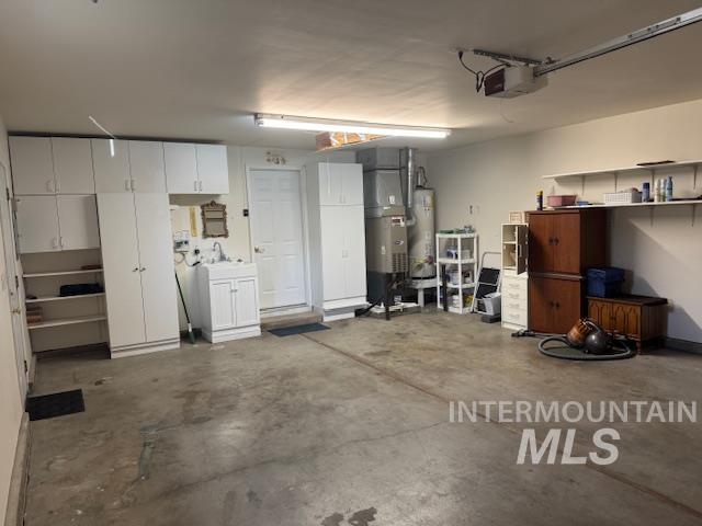 Garage with water heater, heating unit, and a garage door opener