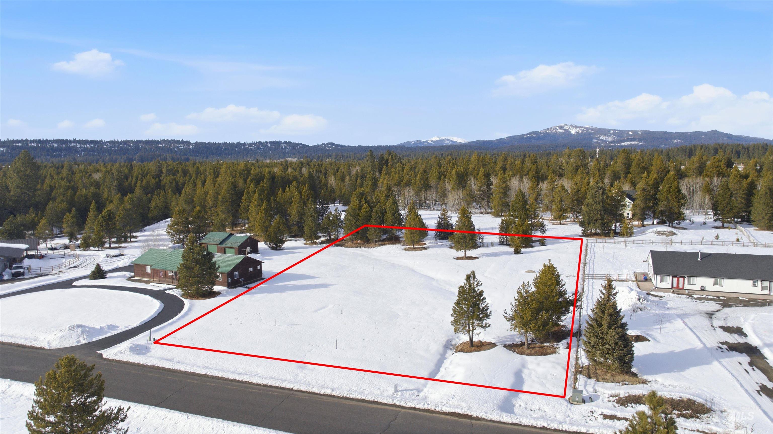 Aerial overview of property's location with property boundaries highlighted and a mountainous background