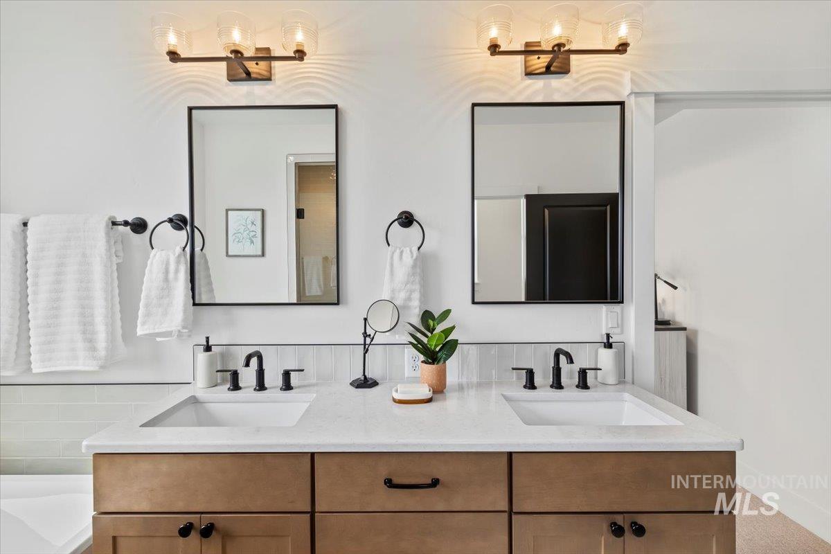 Bathroom with double vanity and a bathtub