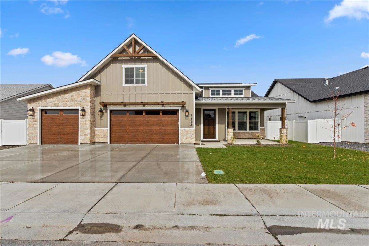 View of front of house featuring board and batten siding, stone siding, covered porch, and driveway