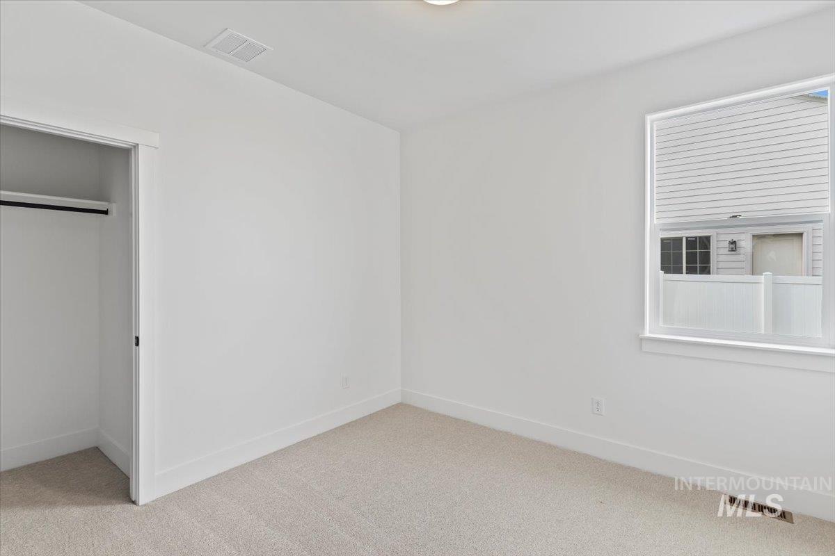 Unfurnished bedroom featuring light colored carpet