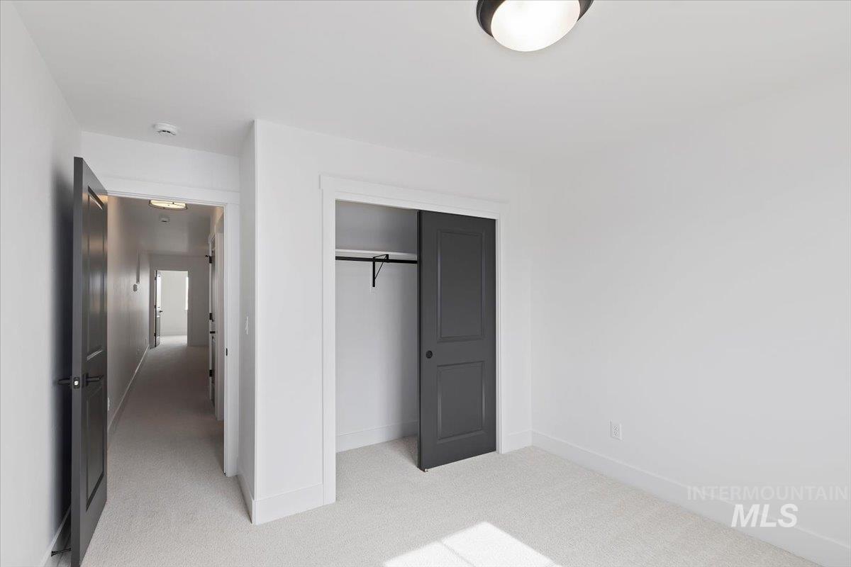 Unfurnished bedroom featuring light colored carpet and a closet