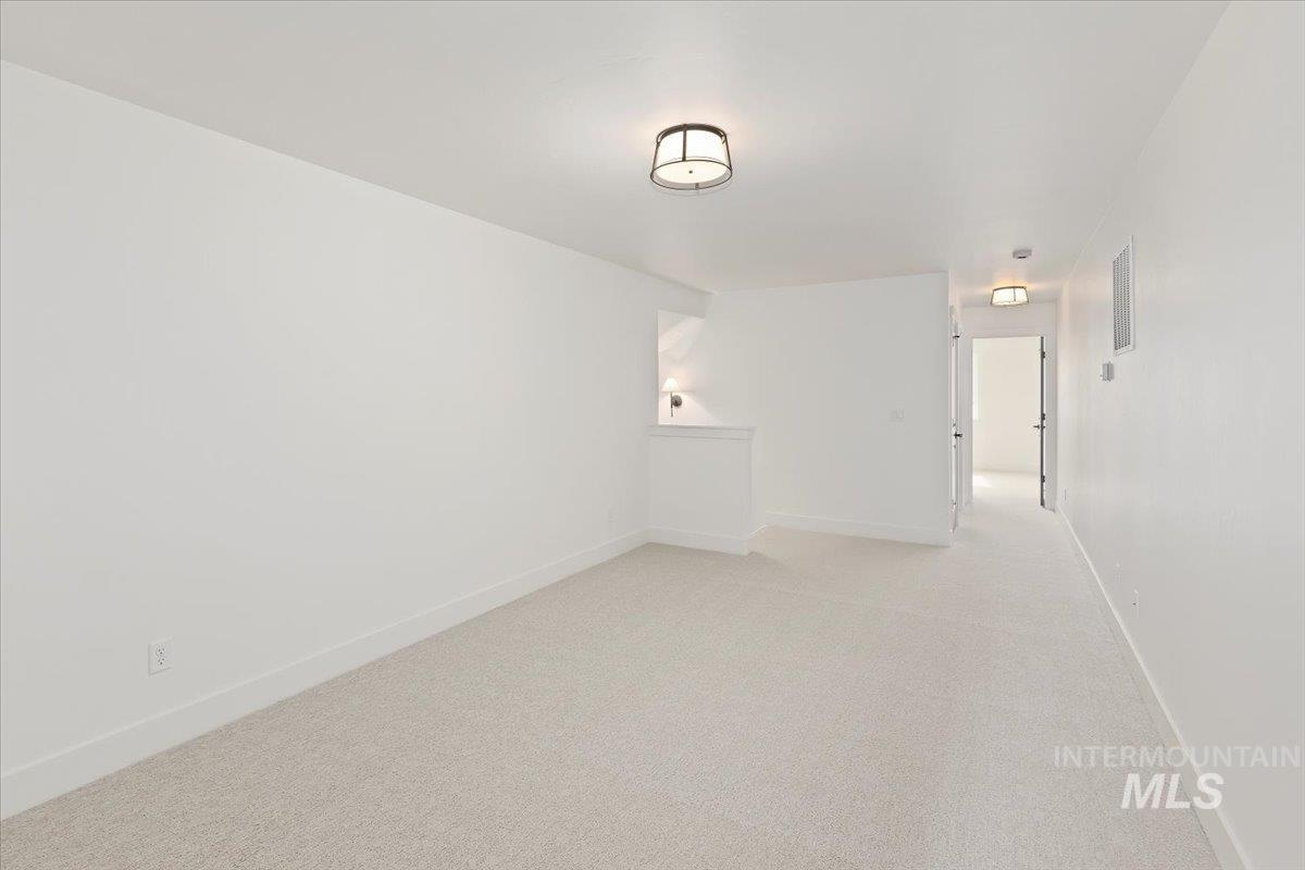 Carpeted empty room featuring baseboards