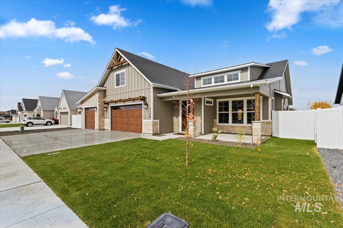 View of front of home with board and batten siding, stone siding, concrete driveway, and a porch
