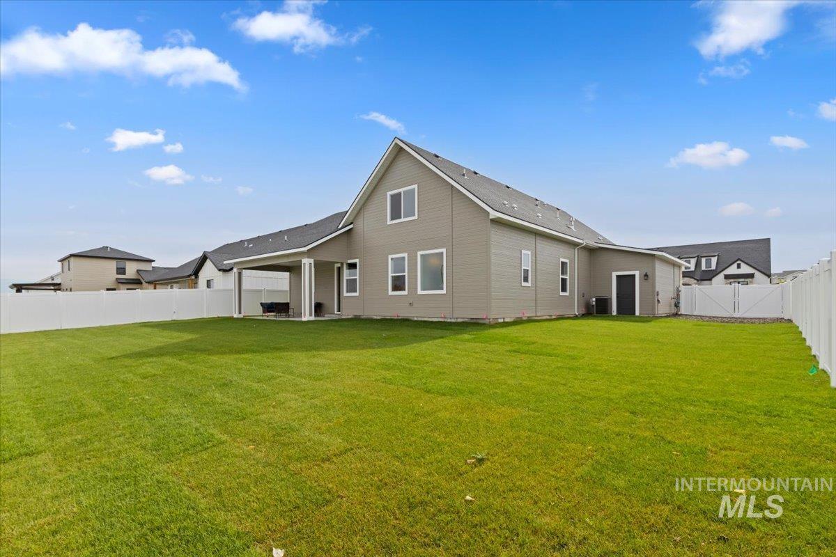 Rear view of house featuring a patio area and a fenced backyard