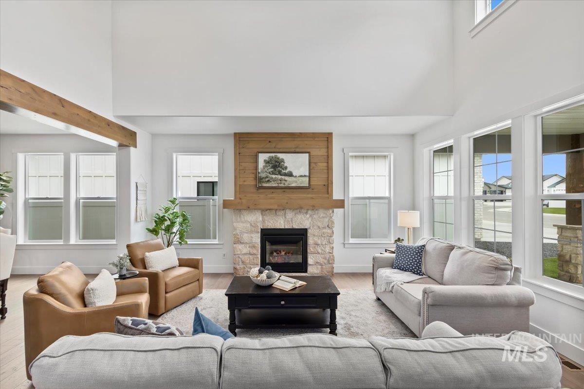 Living room with a towering ceiling, a fireplace, and wood finished floors