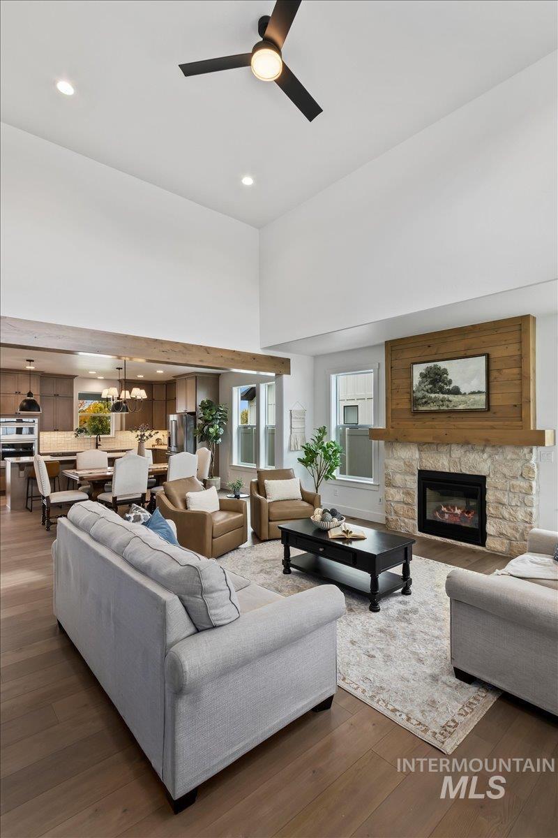 Living area with wood finished floors, a fireplace, recessed lighting, ceiling fan, and a chandelier