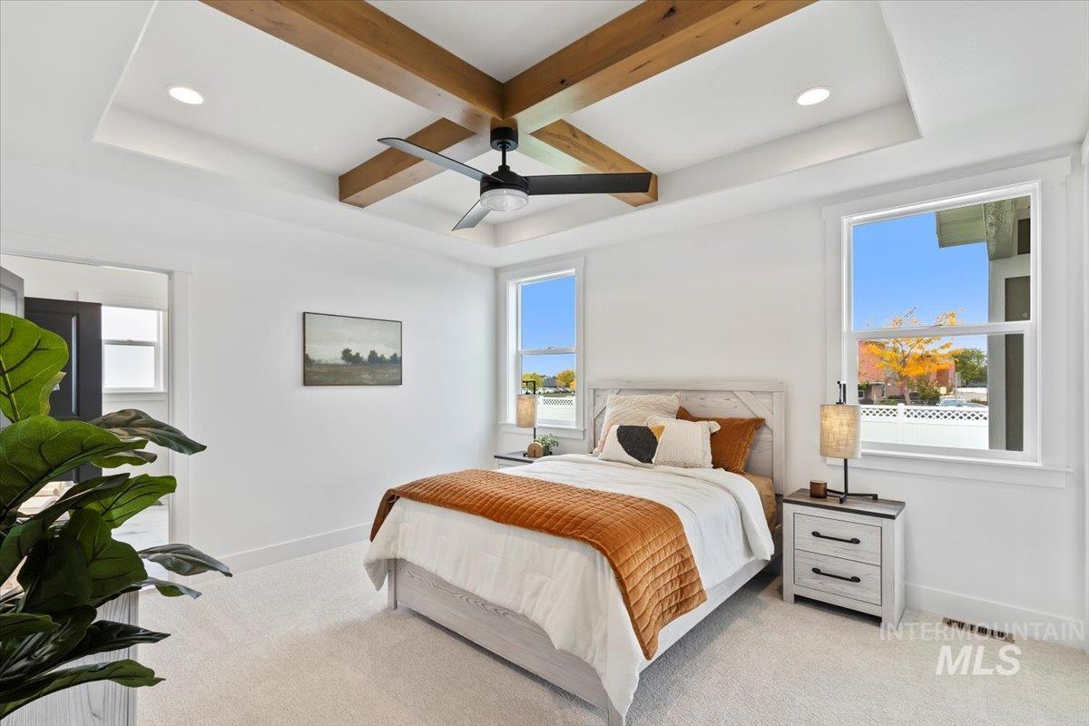 Carpeted bedroom with coffered ceiling, beam ceiling, recessed lighting, and ceiling fan
