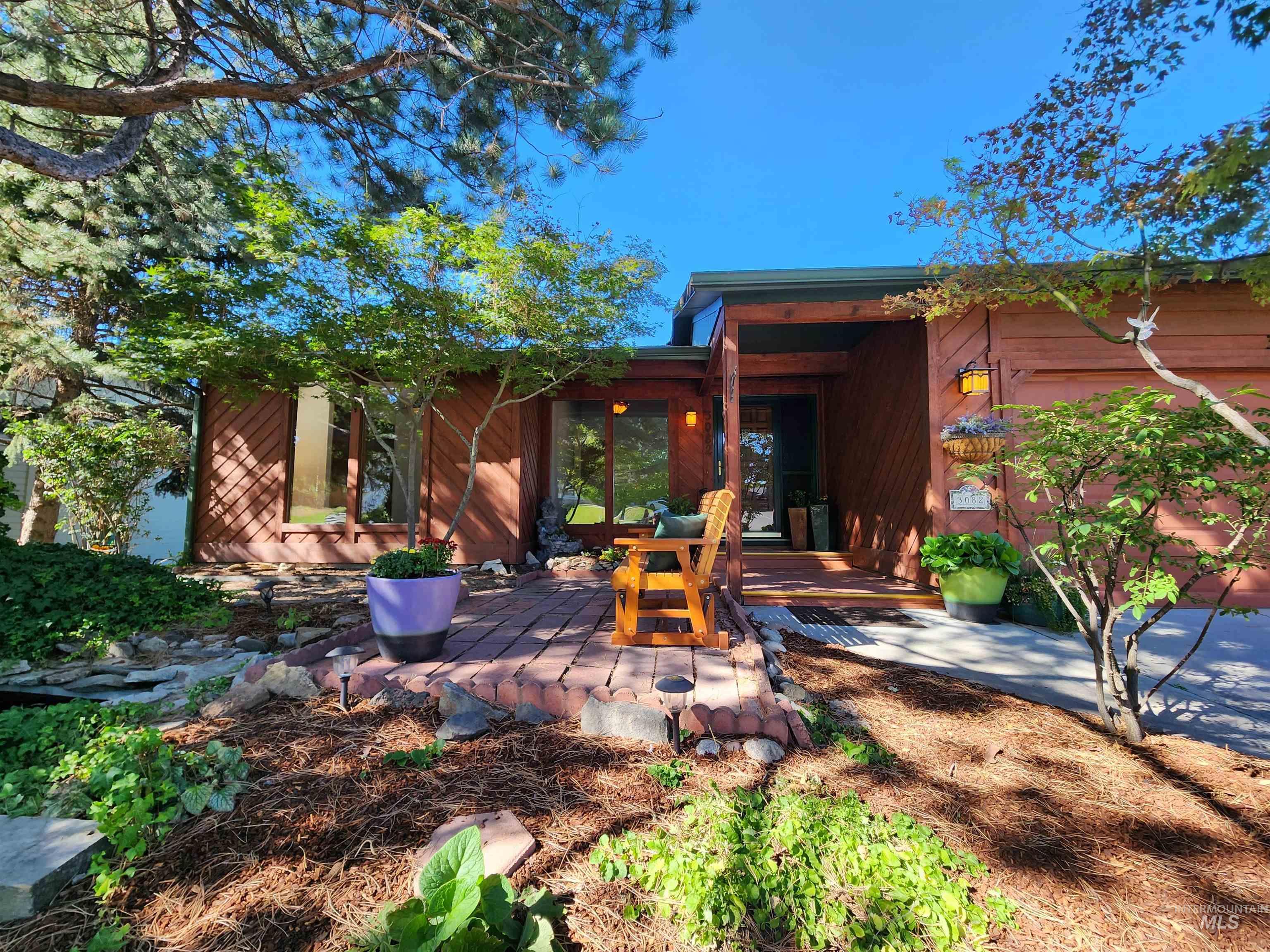 Back of property featuring a wooden deck and a patio area