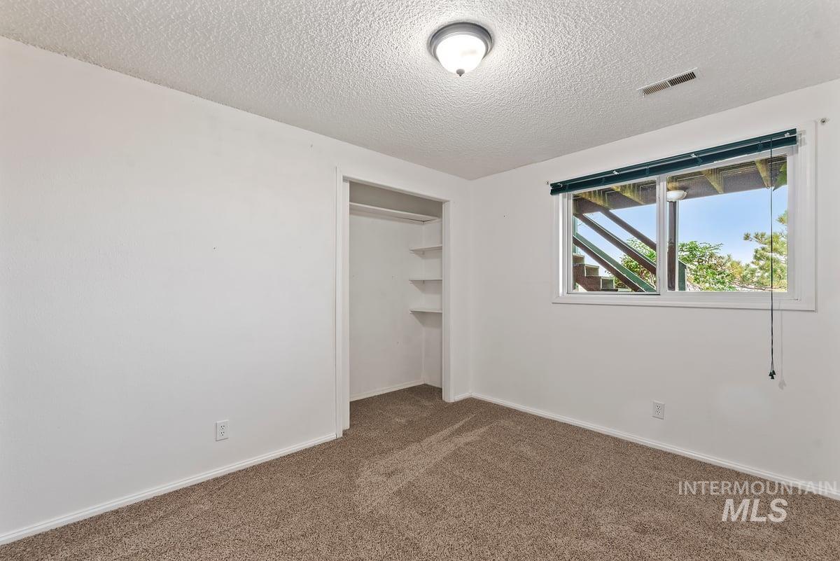 Unfurnished bedroom featuring carpet floors, a closet, and a textured ceiling