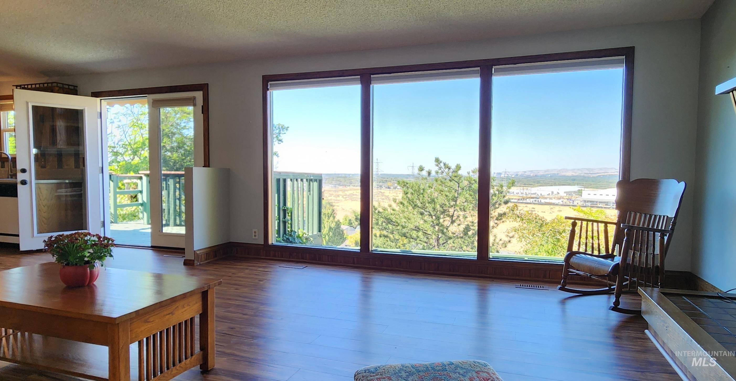 Living area featuring dark wood-type flooring and a textured ceiling