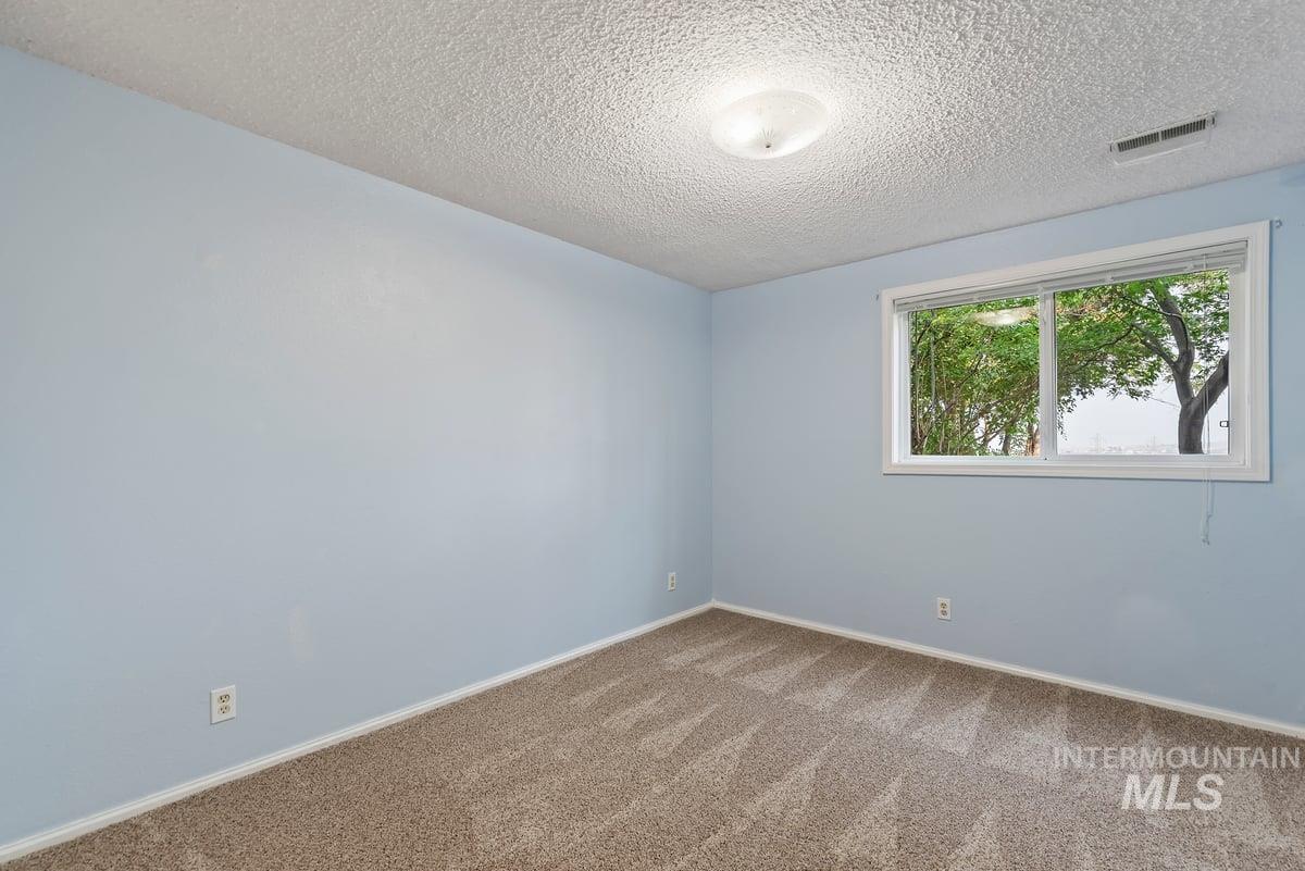 Empty room featuring carpet floors and a textured ceiling