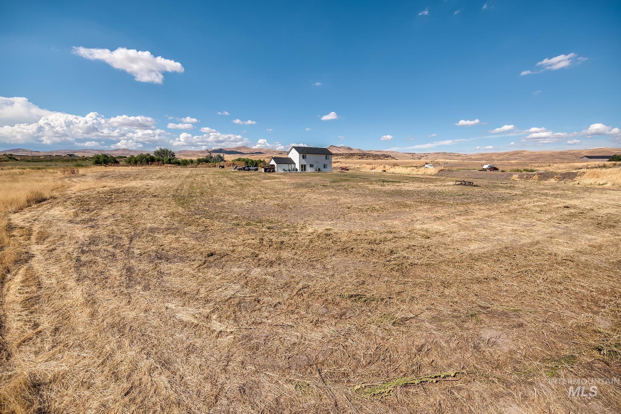 Expansive land parcel featuring a distant single-family home