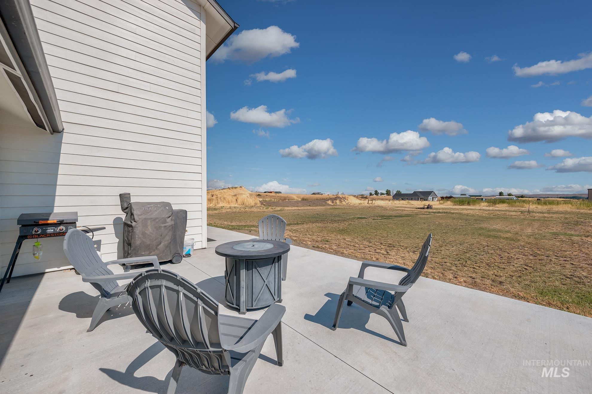 Concrete patio extending from the white horizontal siding of the property, offering an expansive outdoor space