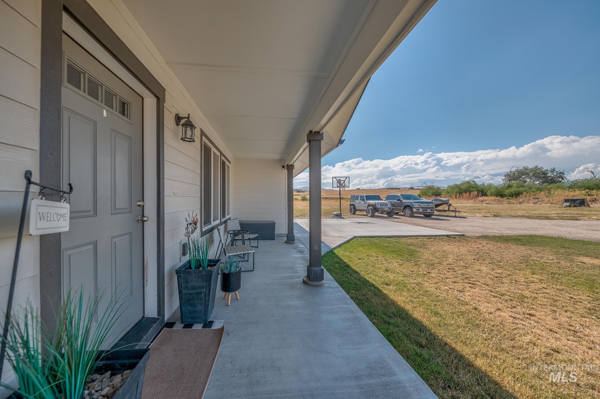 Covered porch featuring a paneled entry door with transom window, exterior lighting fixture, and horizontal siding