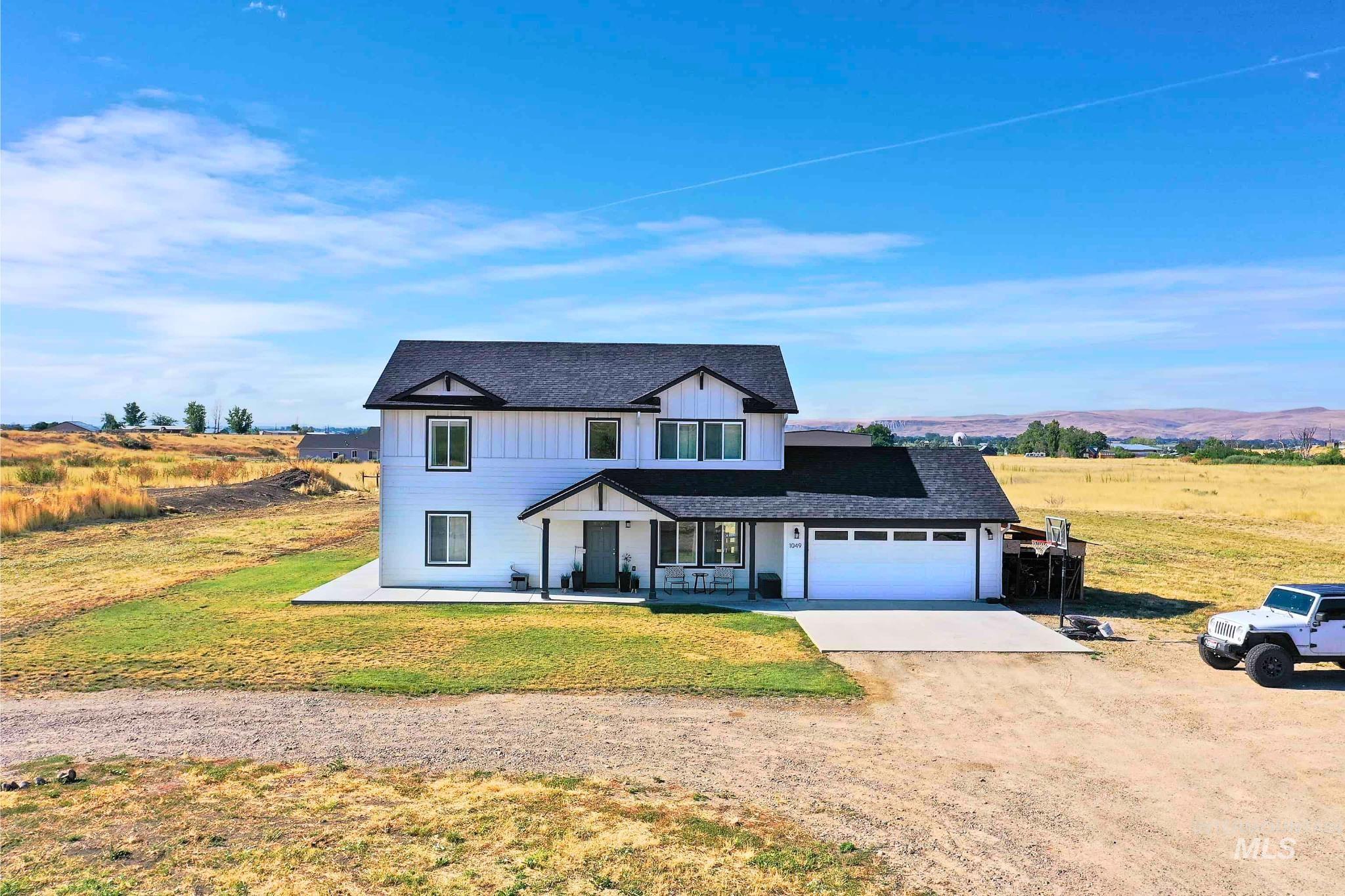 Two-story white exterior with dark trim and a covered front porch