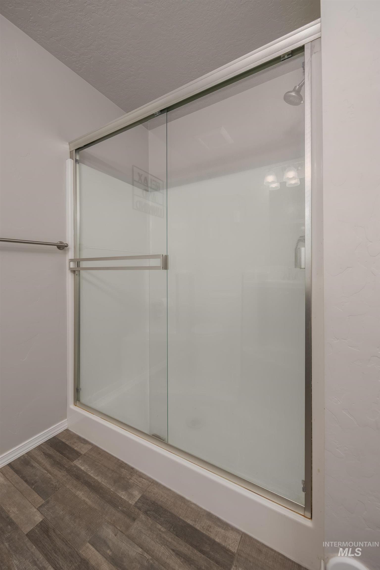 Full shower enclosure featuring sliding glass doors, chrome hardware, and a durable white shower base