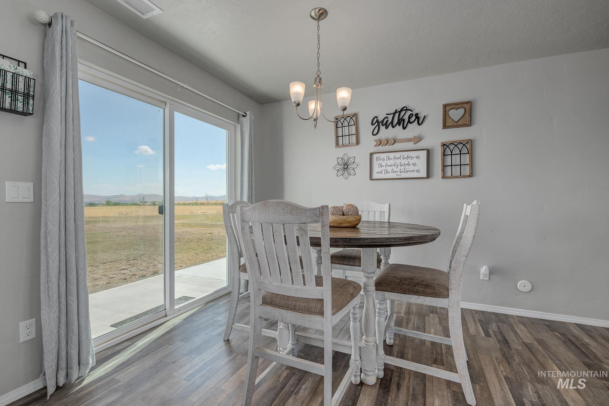 Dining area featuring wood-finish flooring and a contemporary chandelier