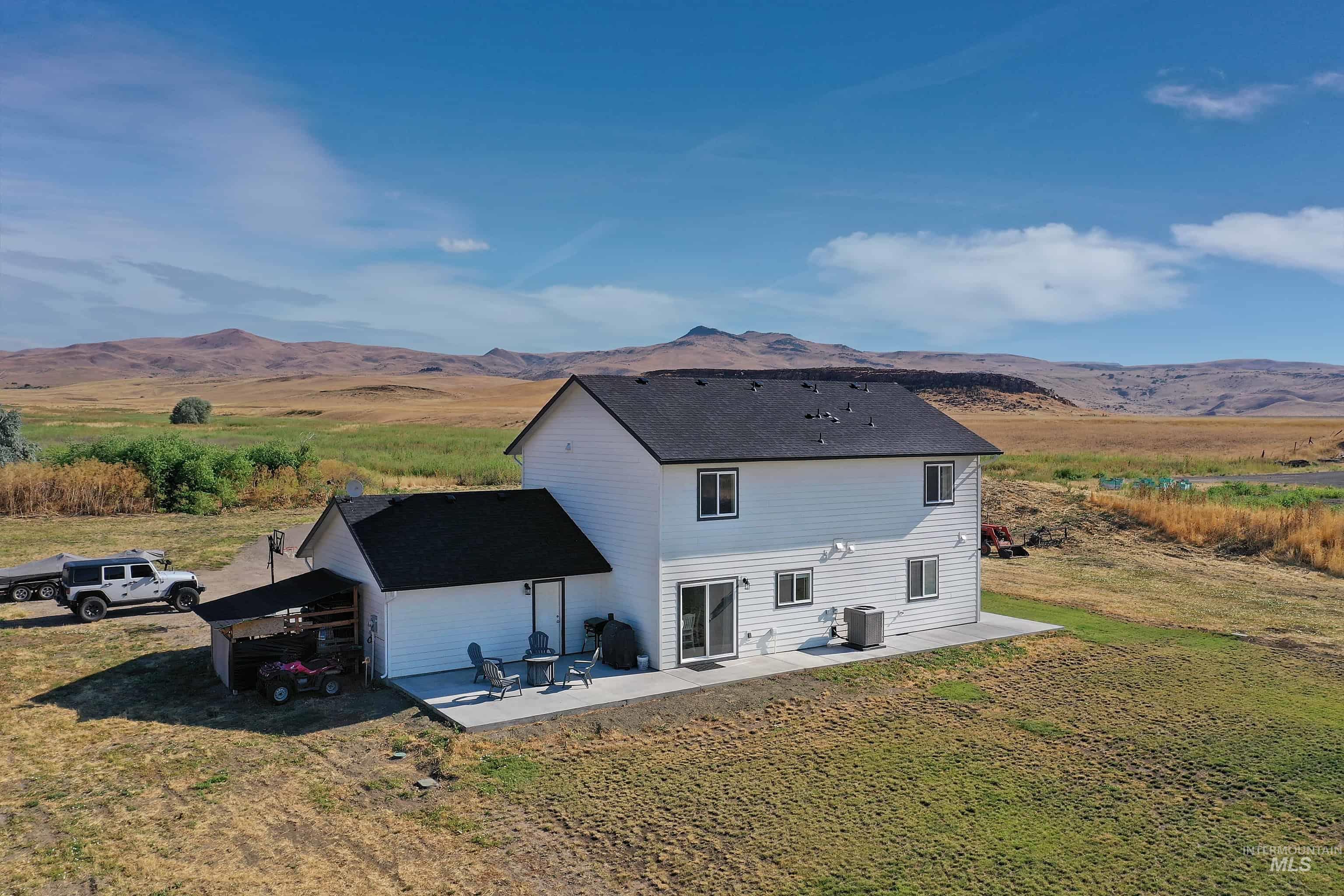 Two-story white siding residence featuring a black shingle roof