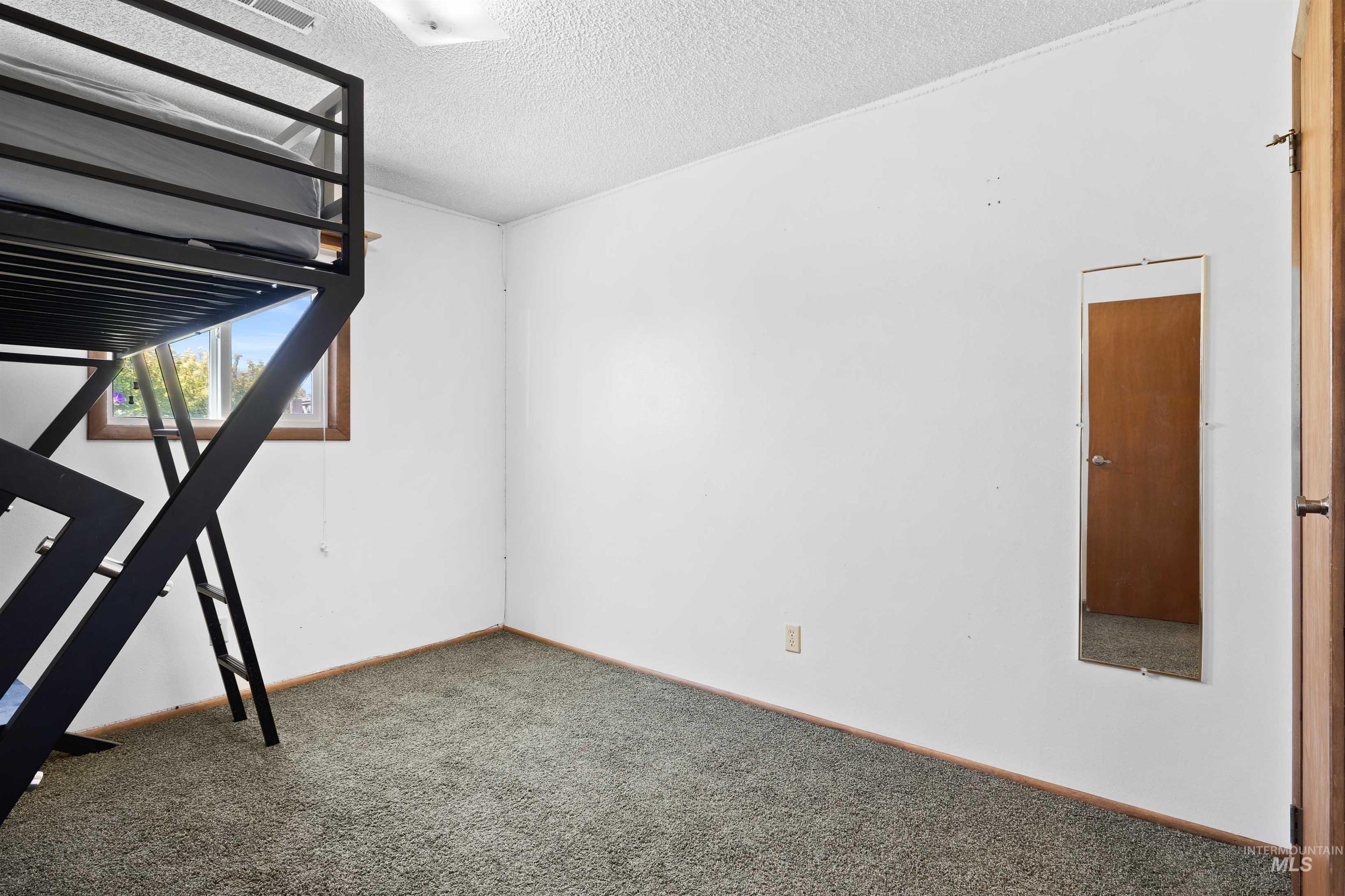 Unfurnished bedroom featuring carpet floors and a textured ceiling