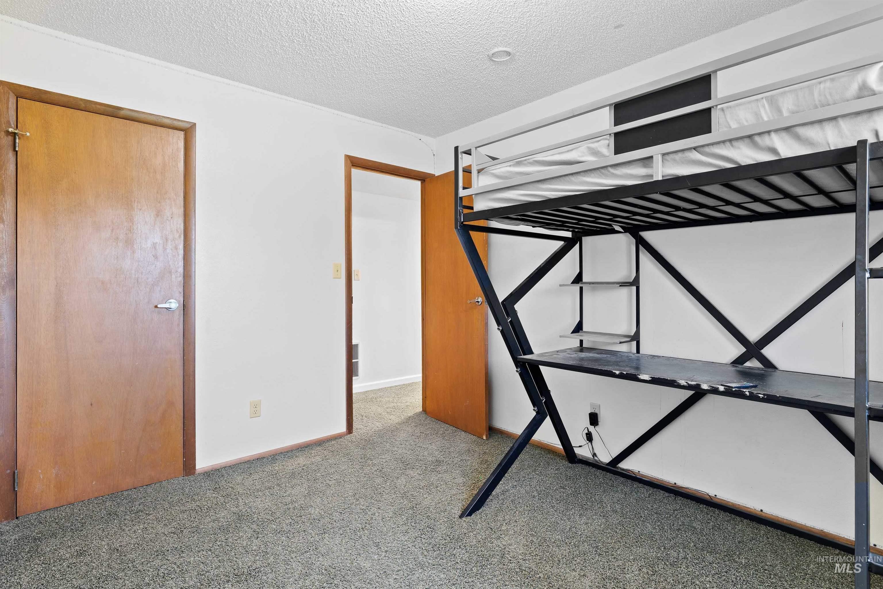 Unfurnished bedroom featuring carpet and a textured ceiling