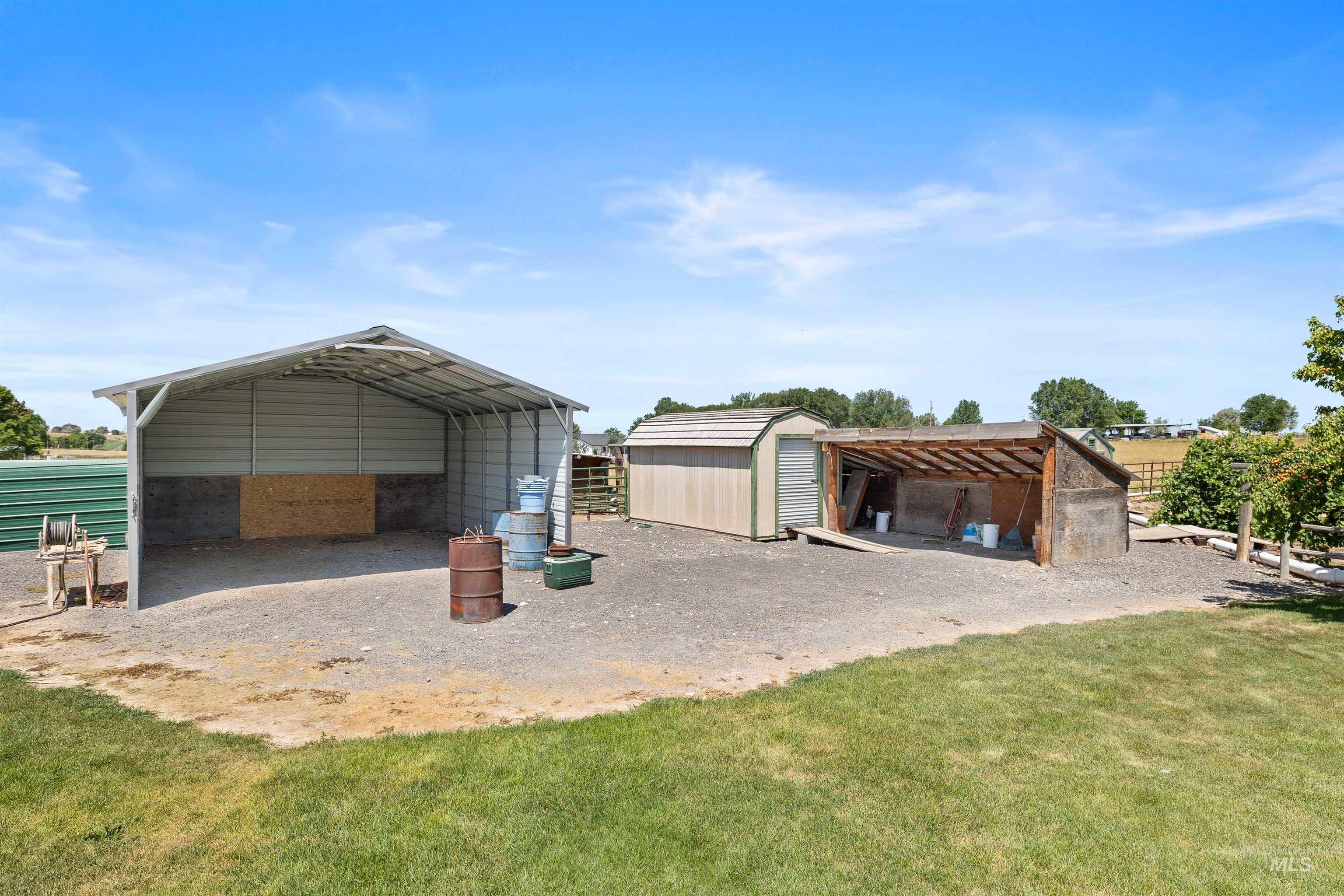 Garage featuring a detached carport and a storage unit