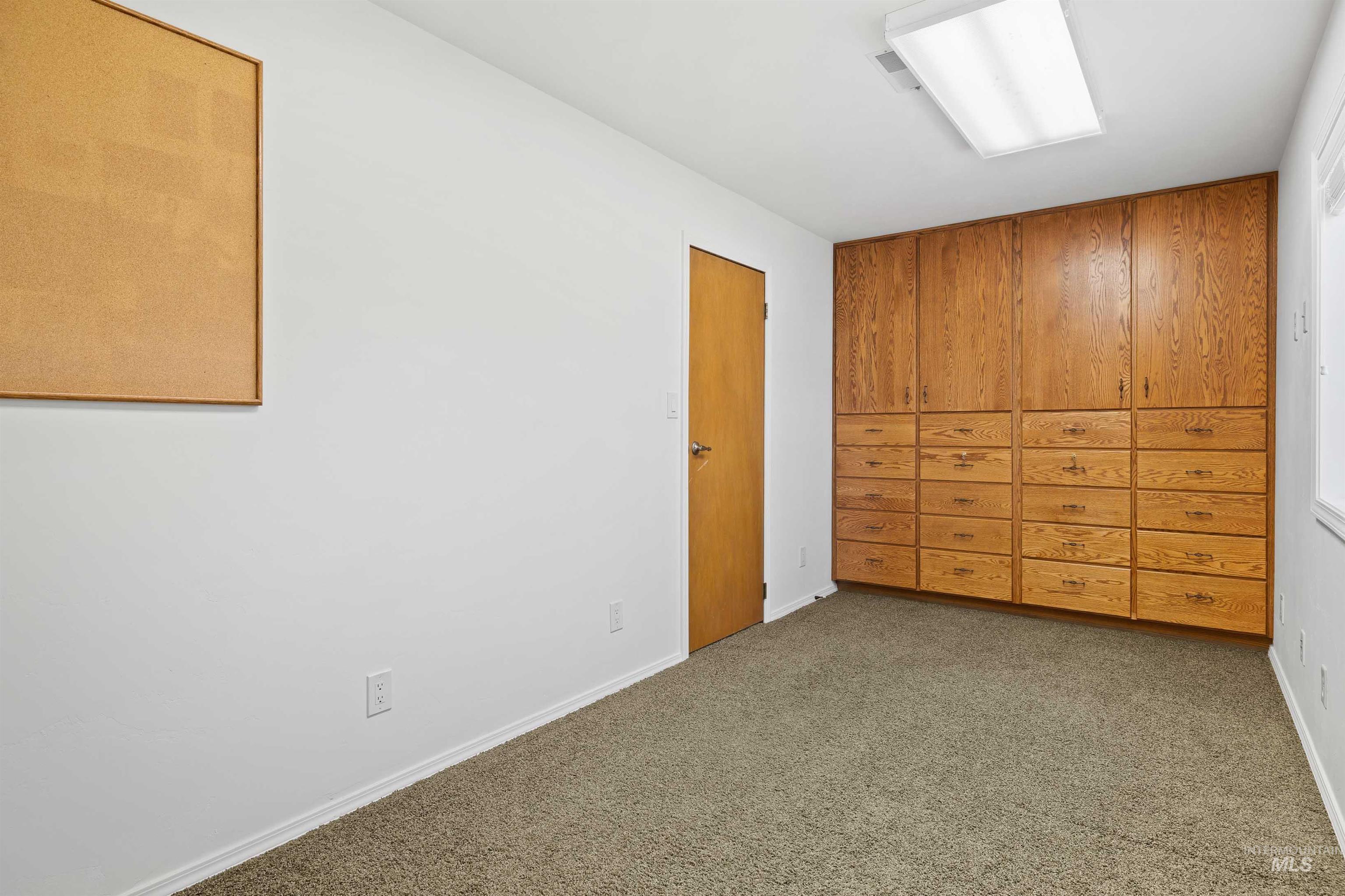 Unfurnished bedroom with carpet floors and baseboards