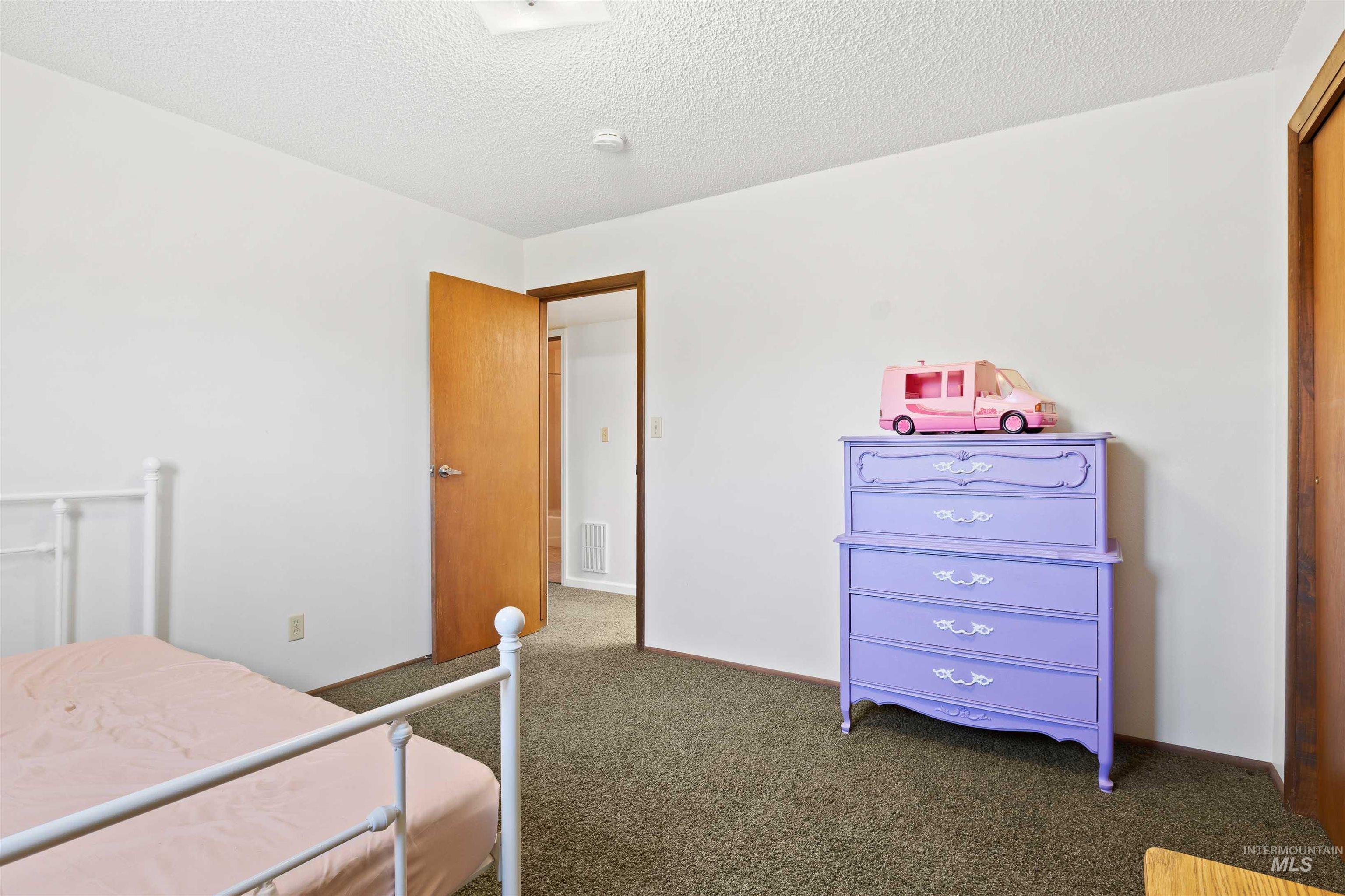 Carpeted bedroom with a textured ceiling