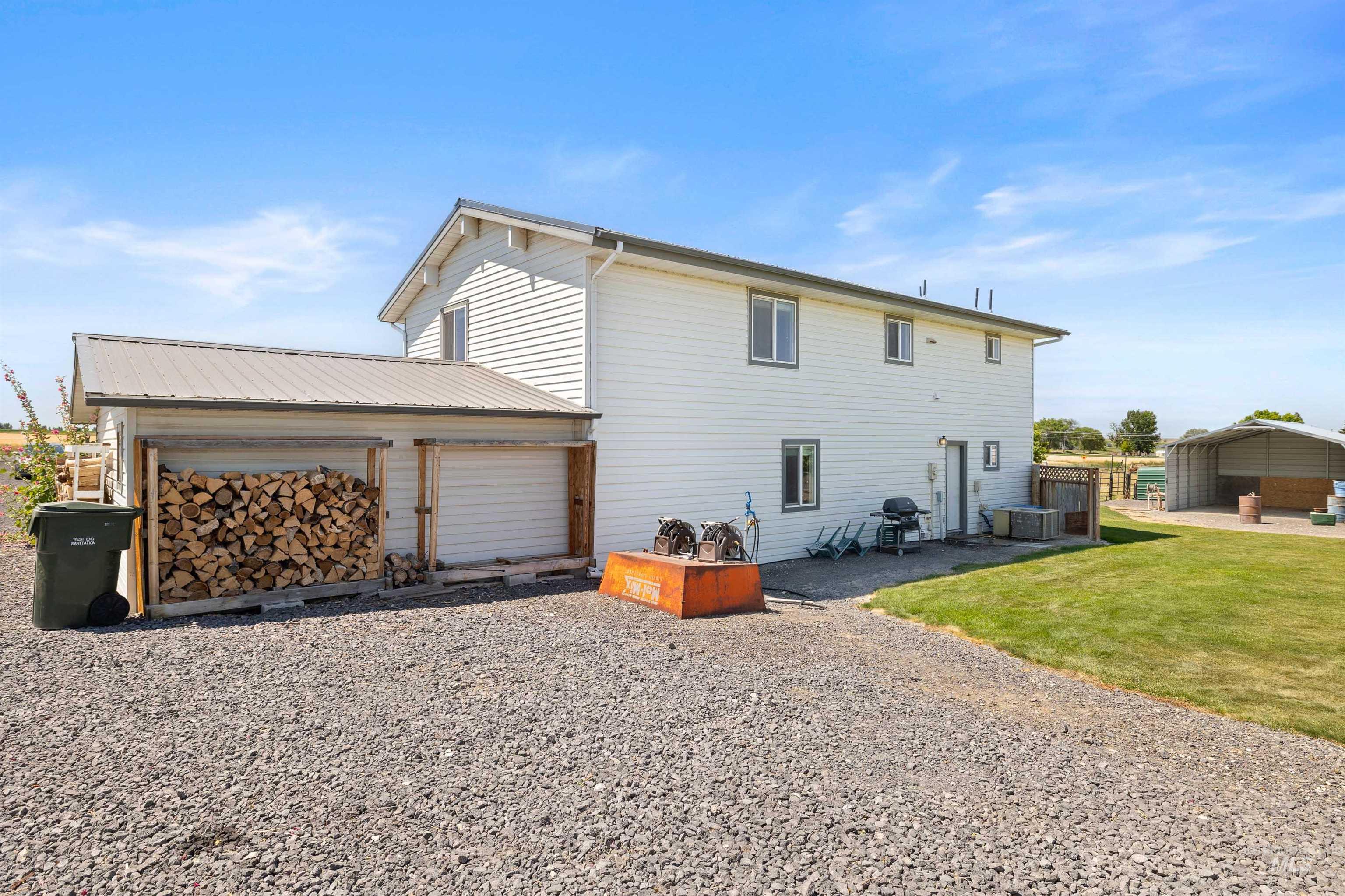 Back of property featuring an attached garage, driveway, and a lawn