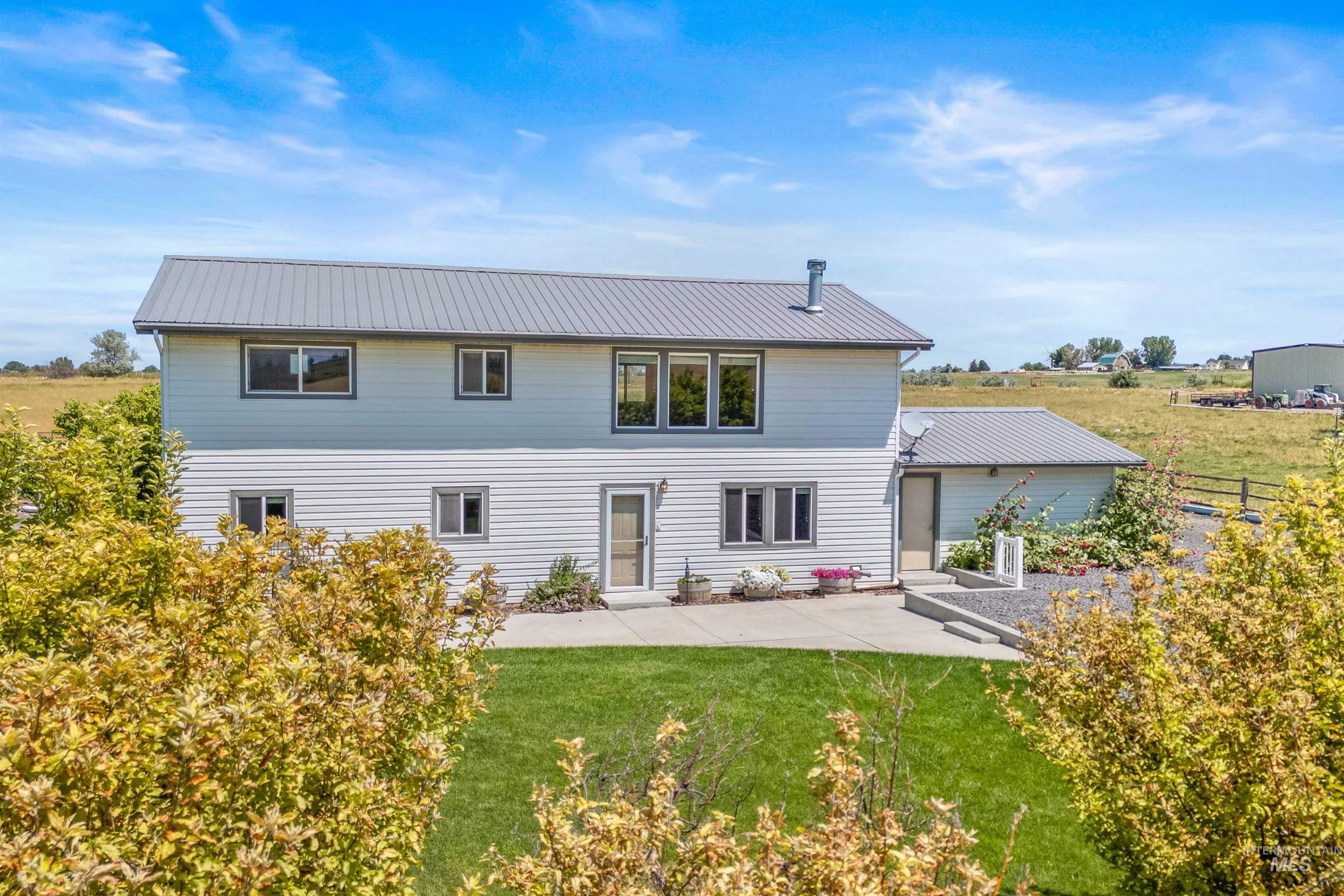 Rear view of property featuring a patio area and a metal roof