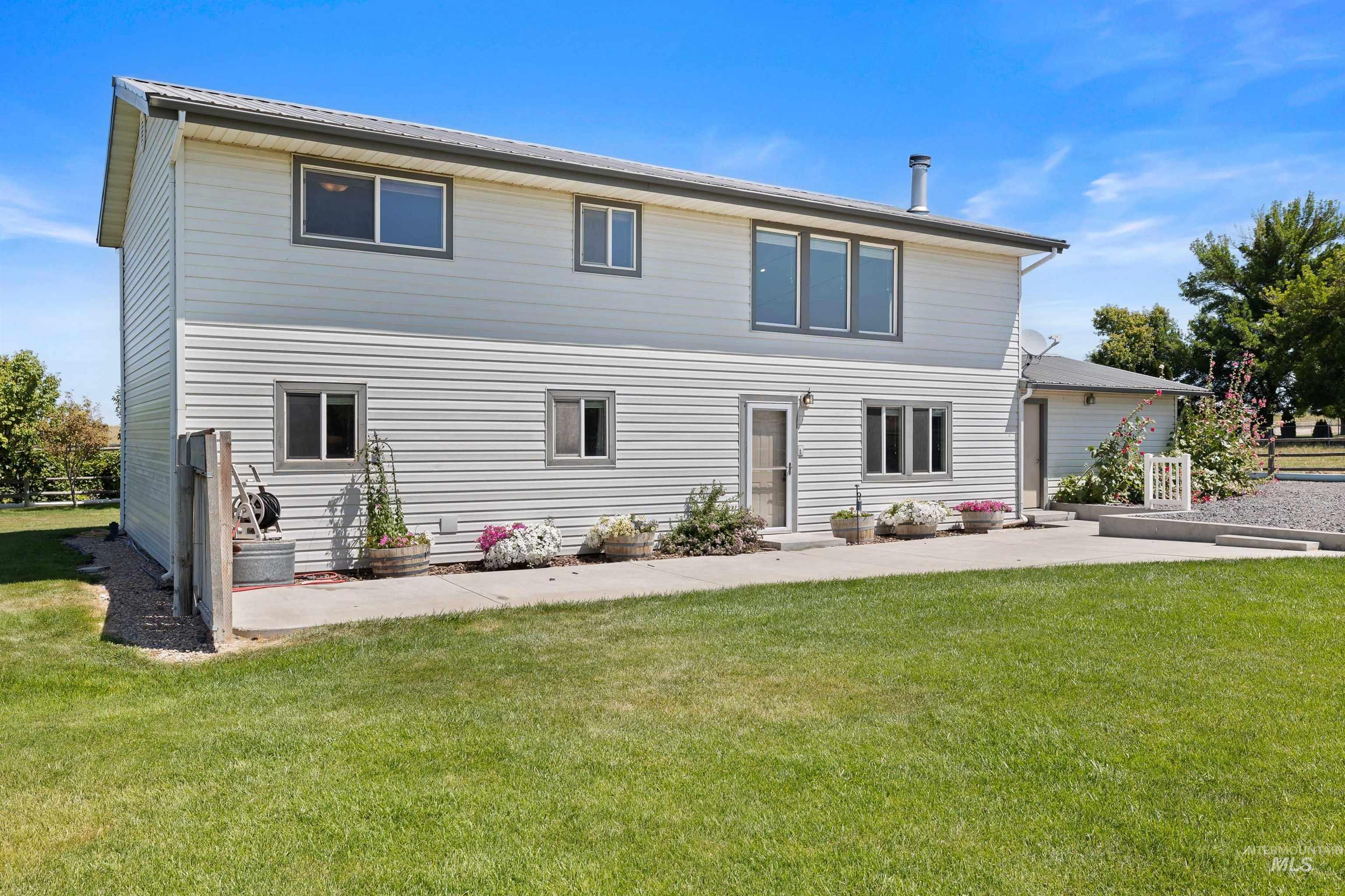 Rear view of house featuring a patio area and a lawn