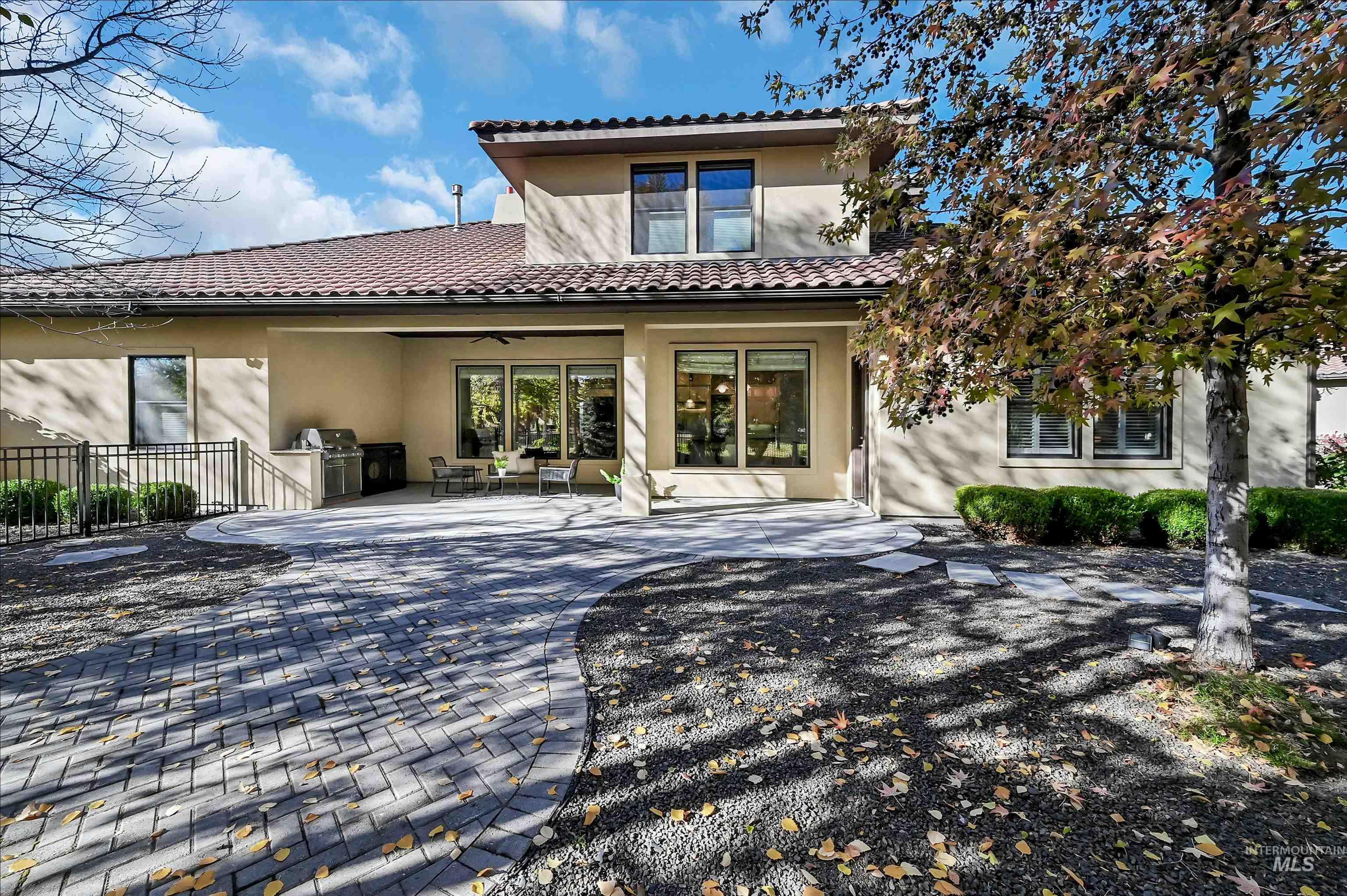 Rear view of property with a patio, stucco siding, a ceiling fan, and a tile roof