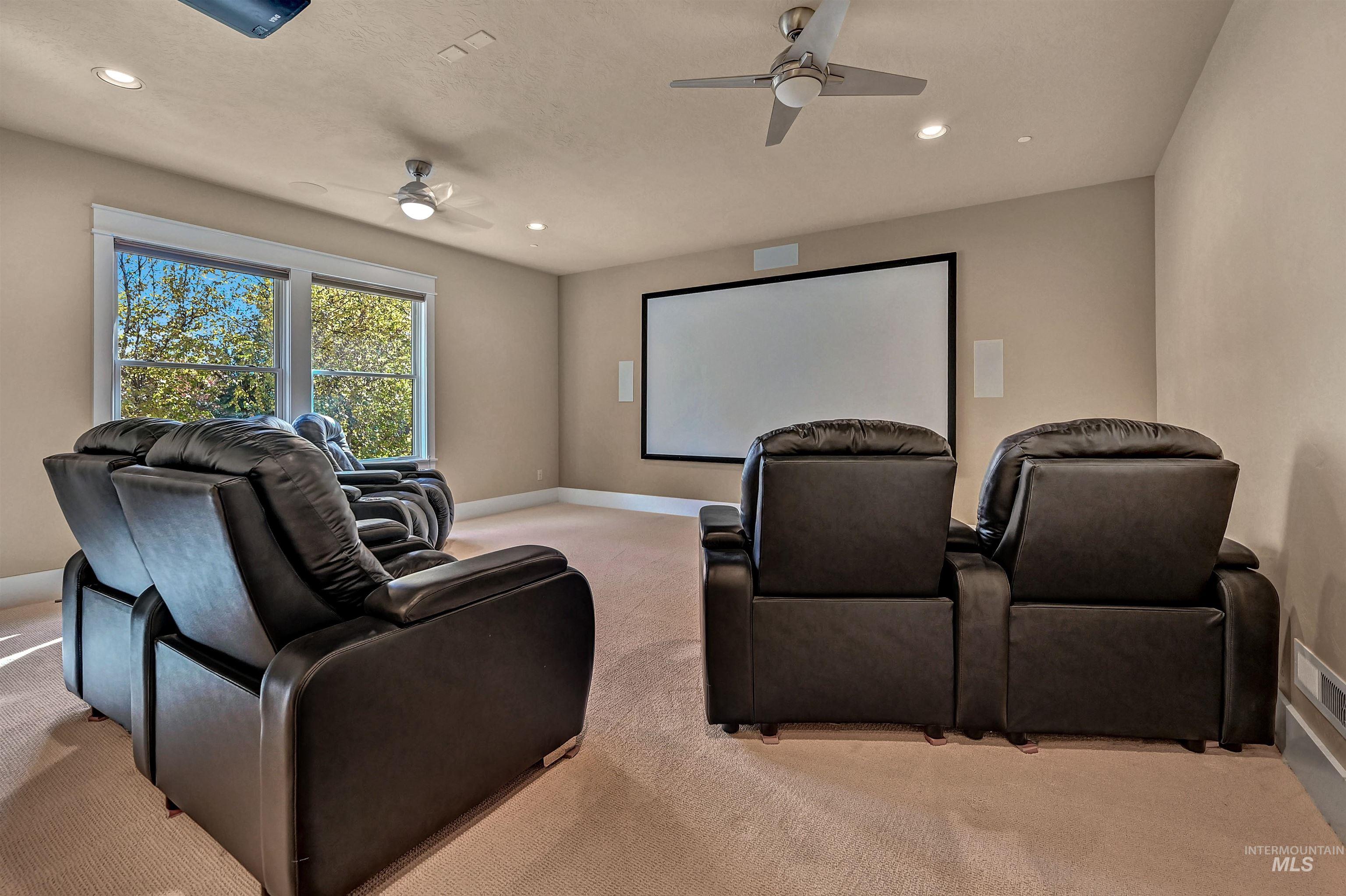 Home theater with light colored carpet, recessed lighting, and ceiling fan