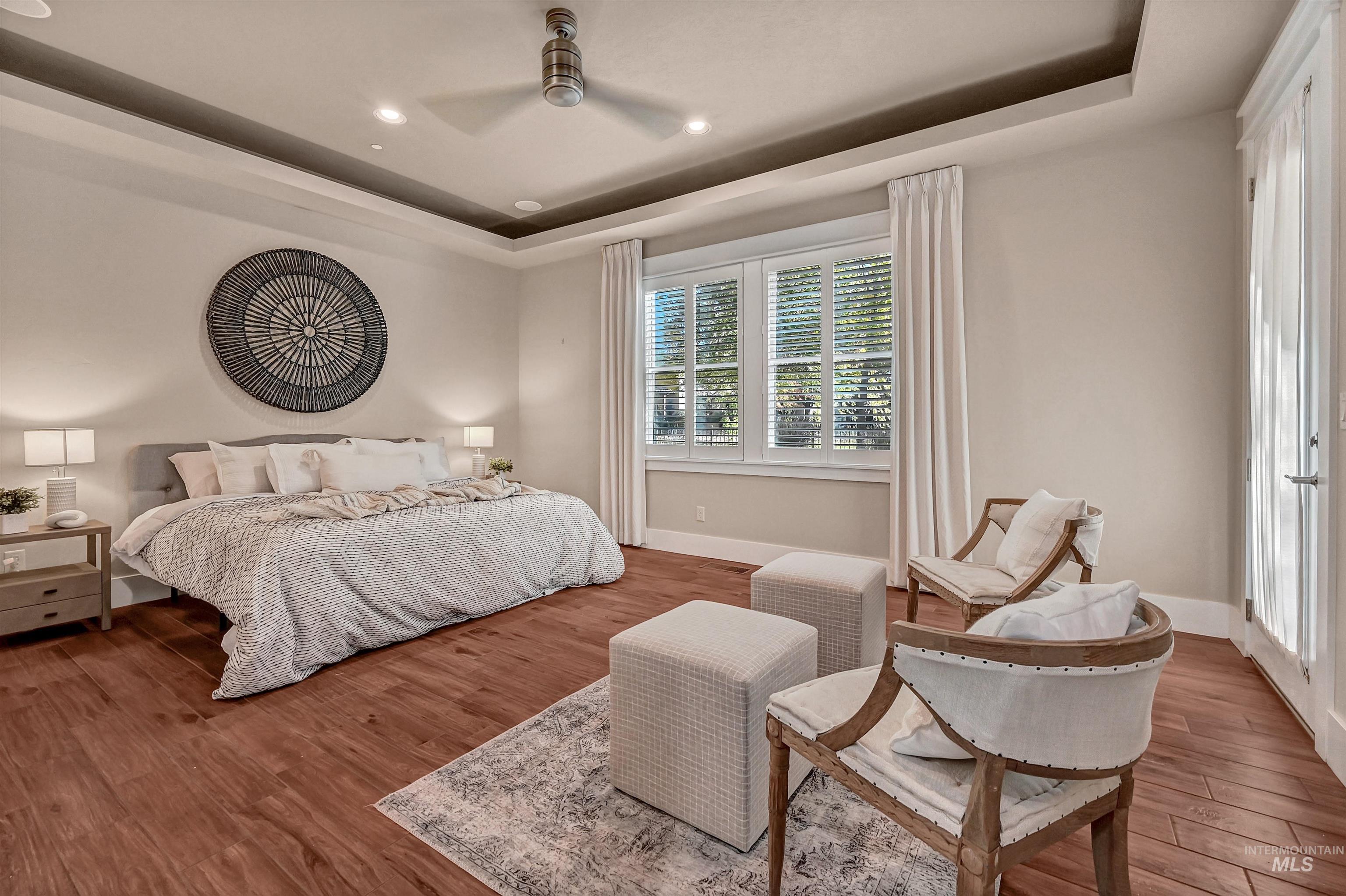 Bedroom featuring a tray ceiling, wood finished floors, a ceiling fan, and recessed lighting