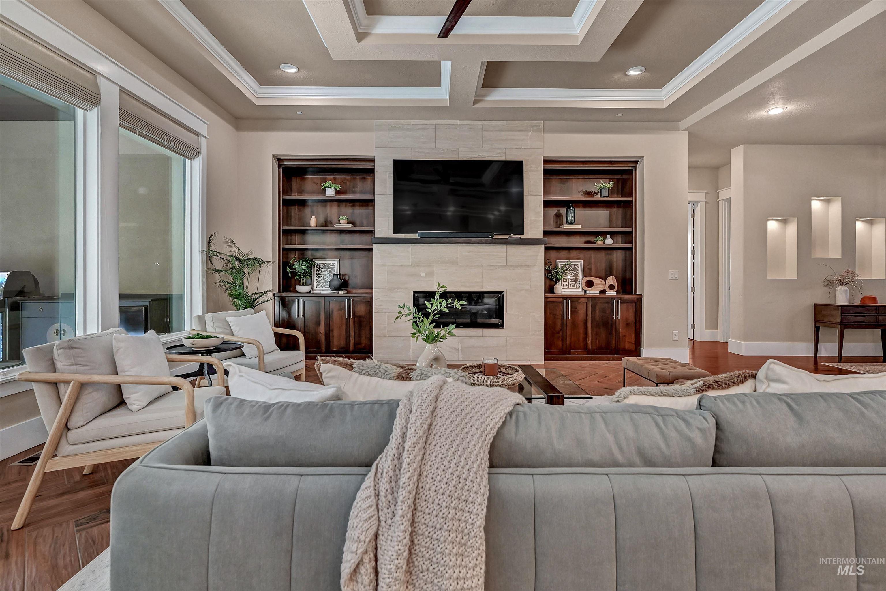 Living room featuring a fireplace, ornamental molding, parquet floors, recessed lighting, and coffered ceiling