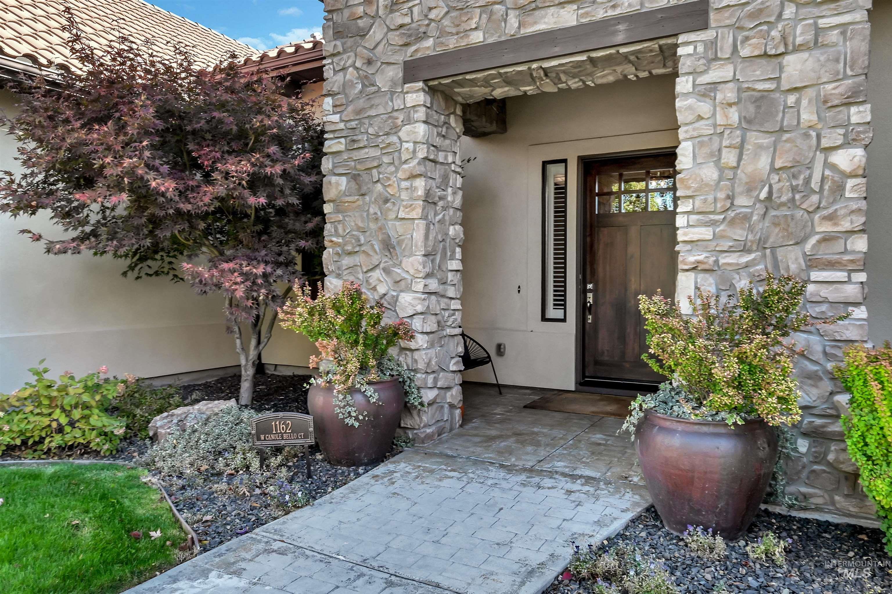 View of exterior entry featuring stone siding and stucco siding