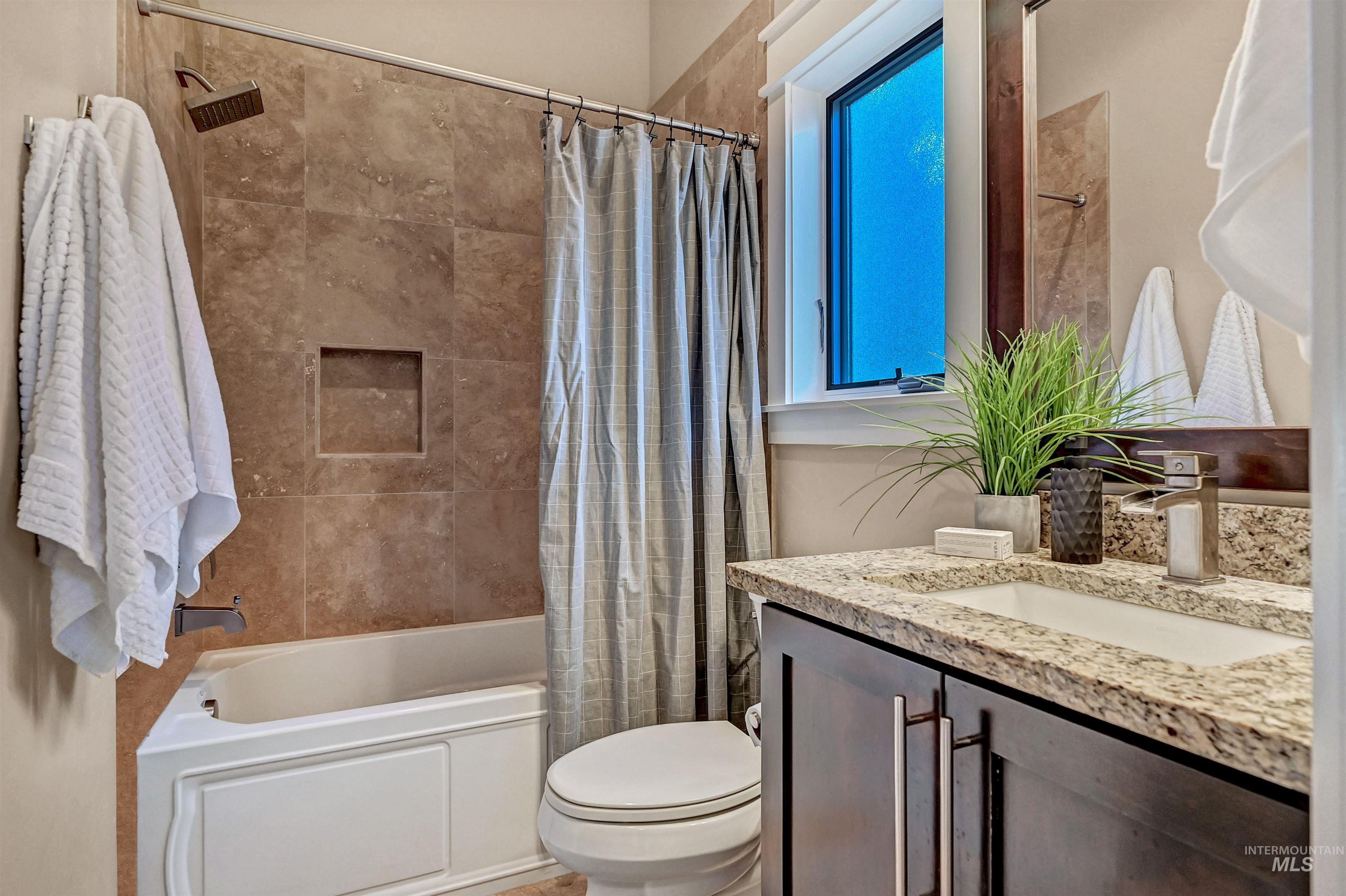 Bathroom with vanity and shower / bathtub combination with curtain
