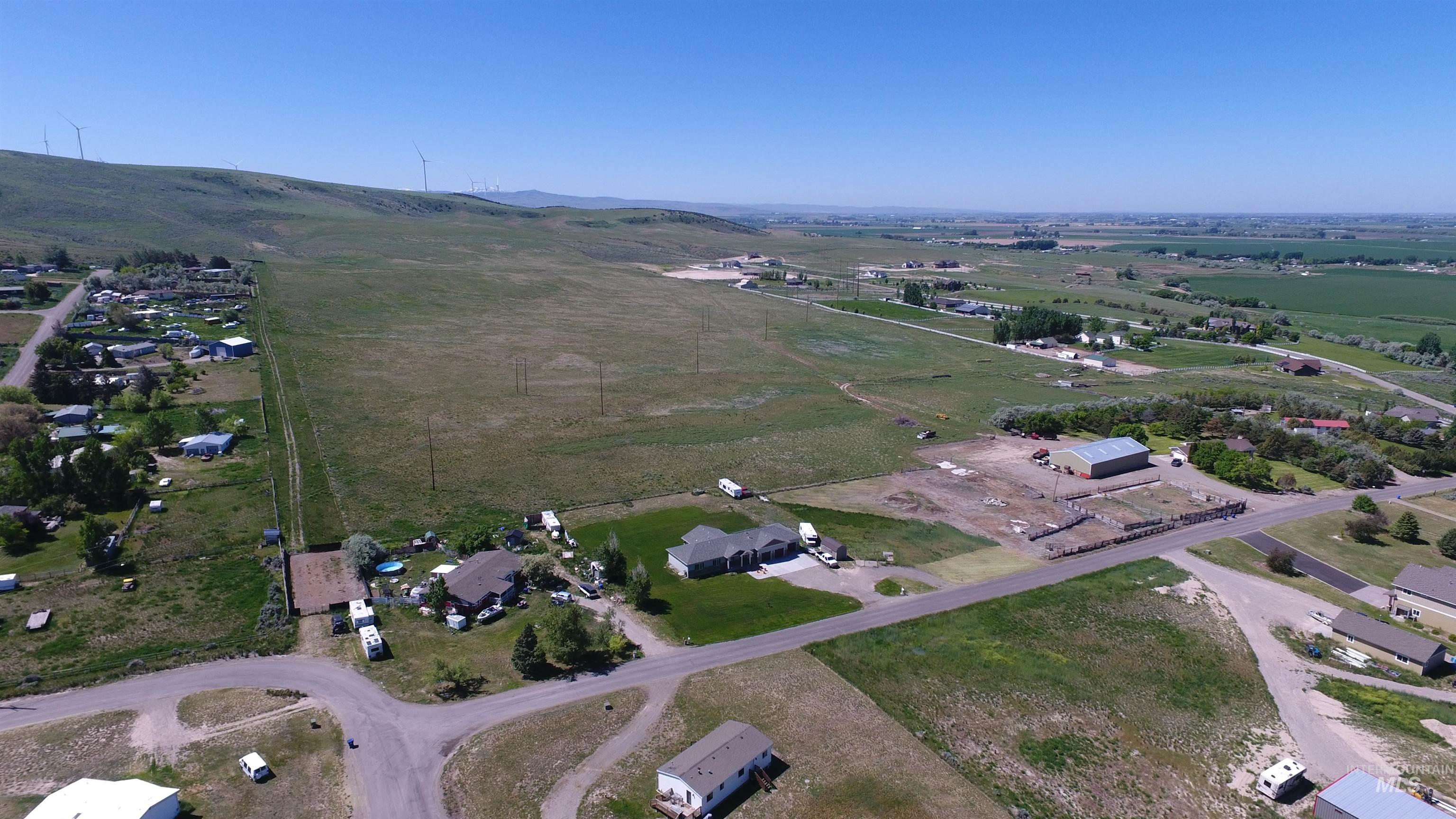 Aerial overview of property's location with rural landscape and a mountainous background