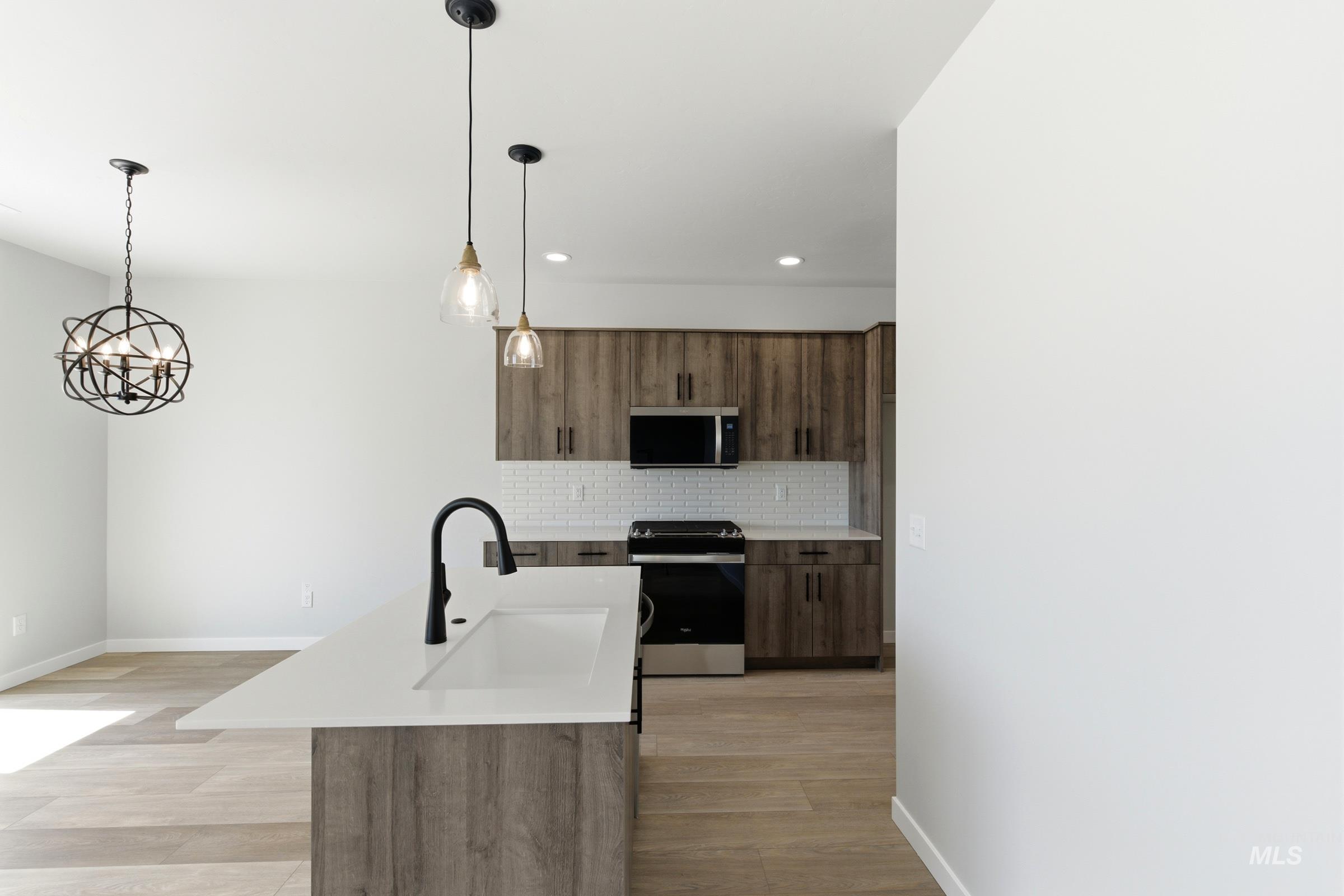 Kitchen island with a white solid surface countertop and undermount sink
