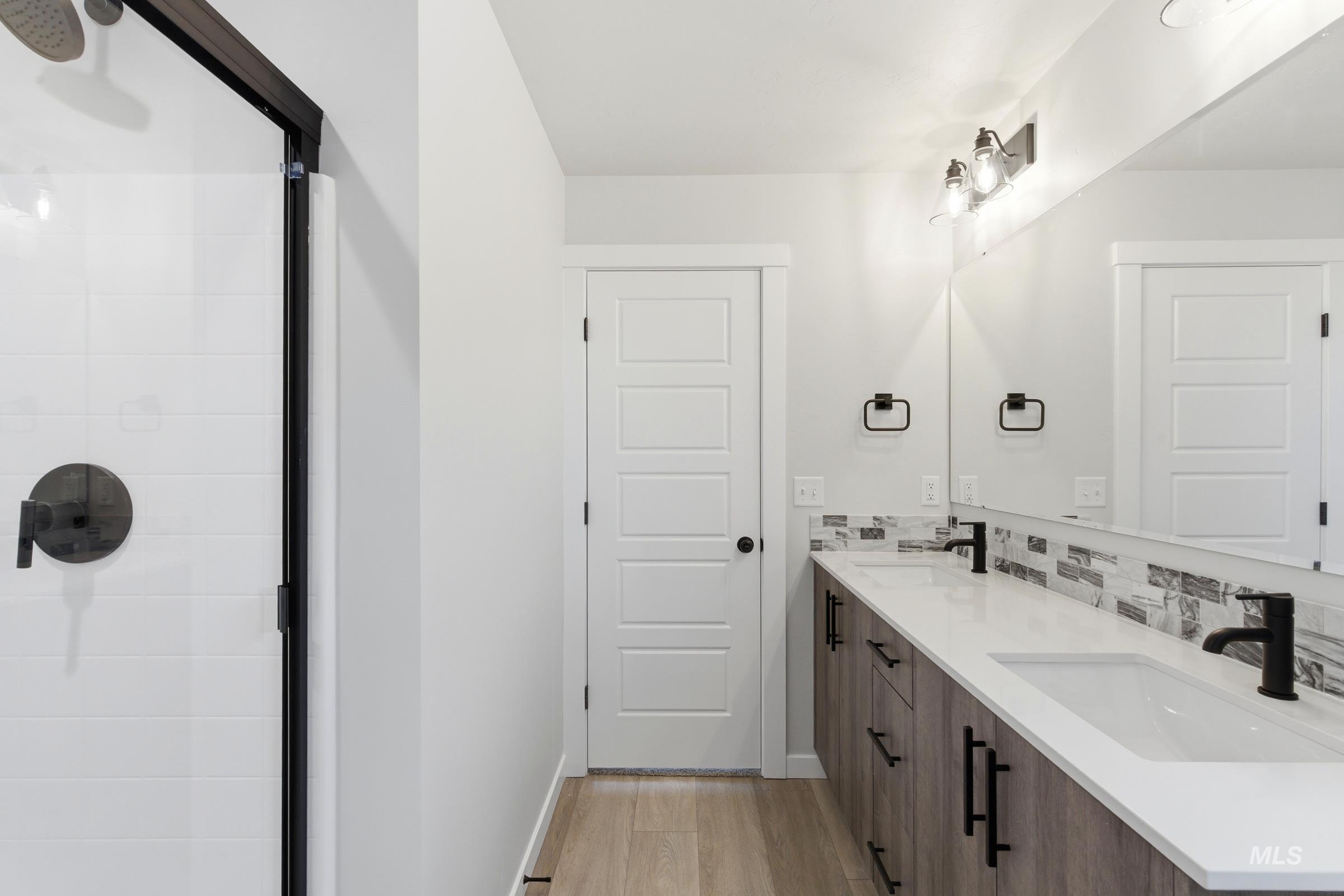 Dual vanity with white undermount sinks, matte black faucets, and a full-width mirror