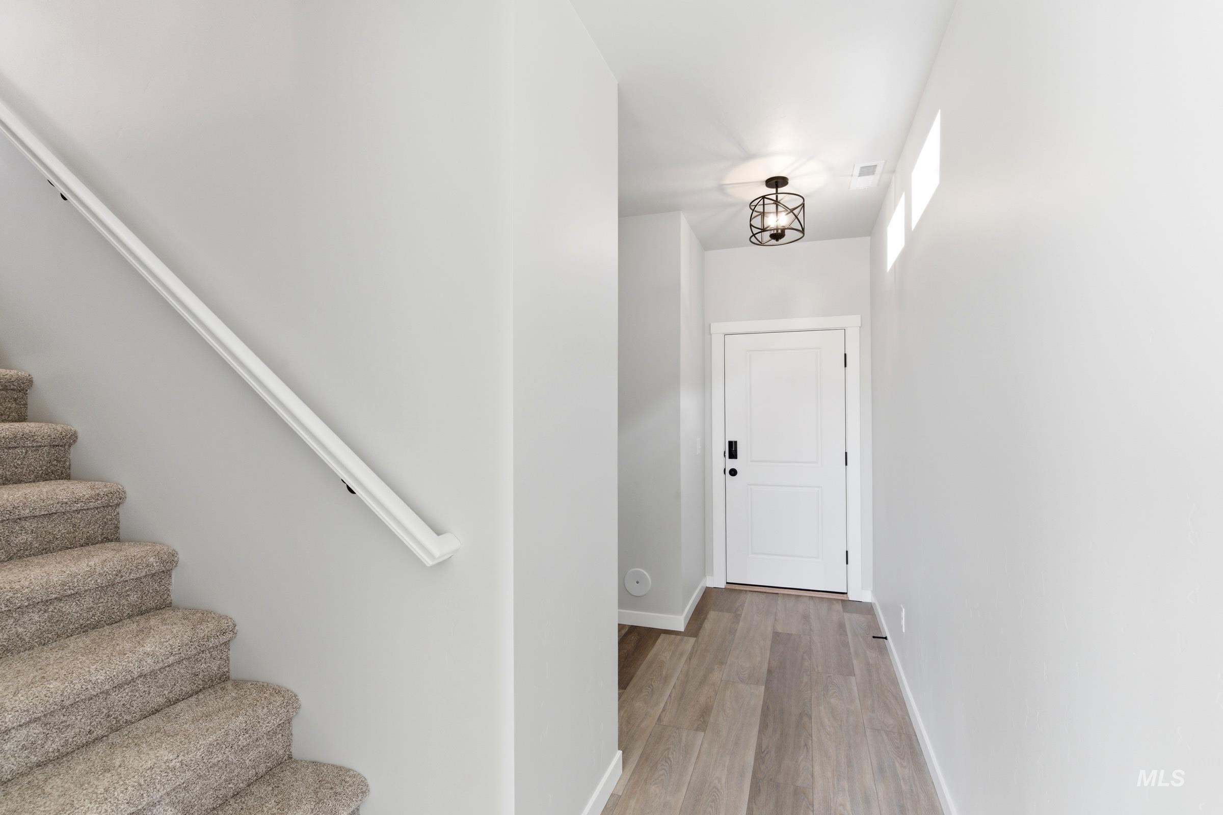 Entryway featuring wood-finish flooring and a white paneled door
