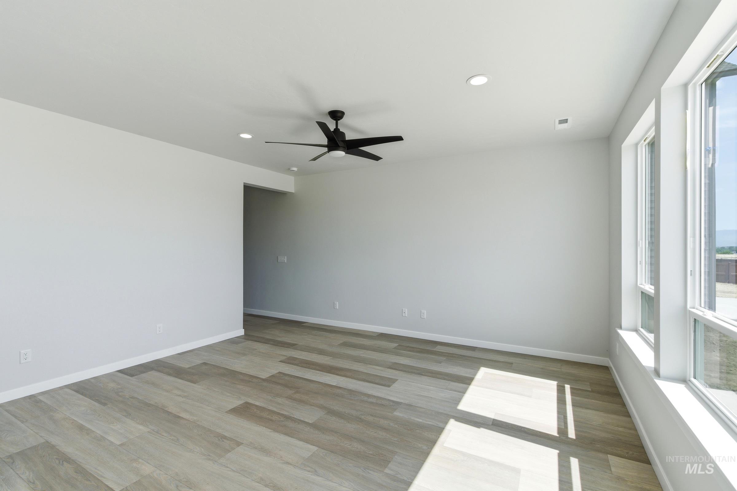 Spacious room featuring wood-finish flooring and expansive windows