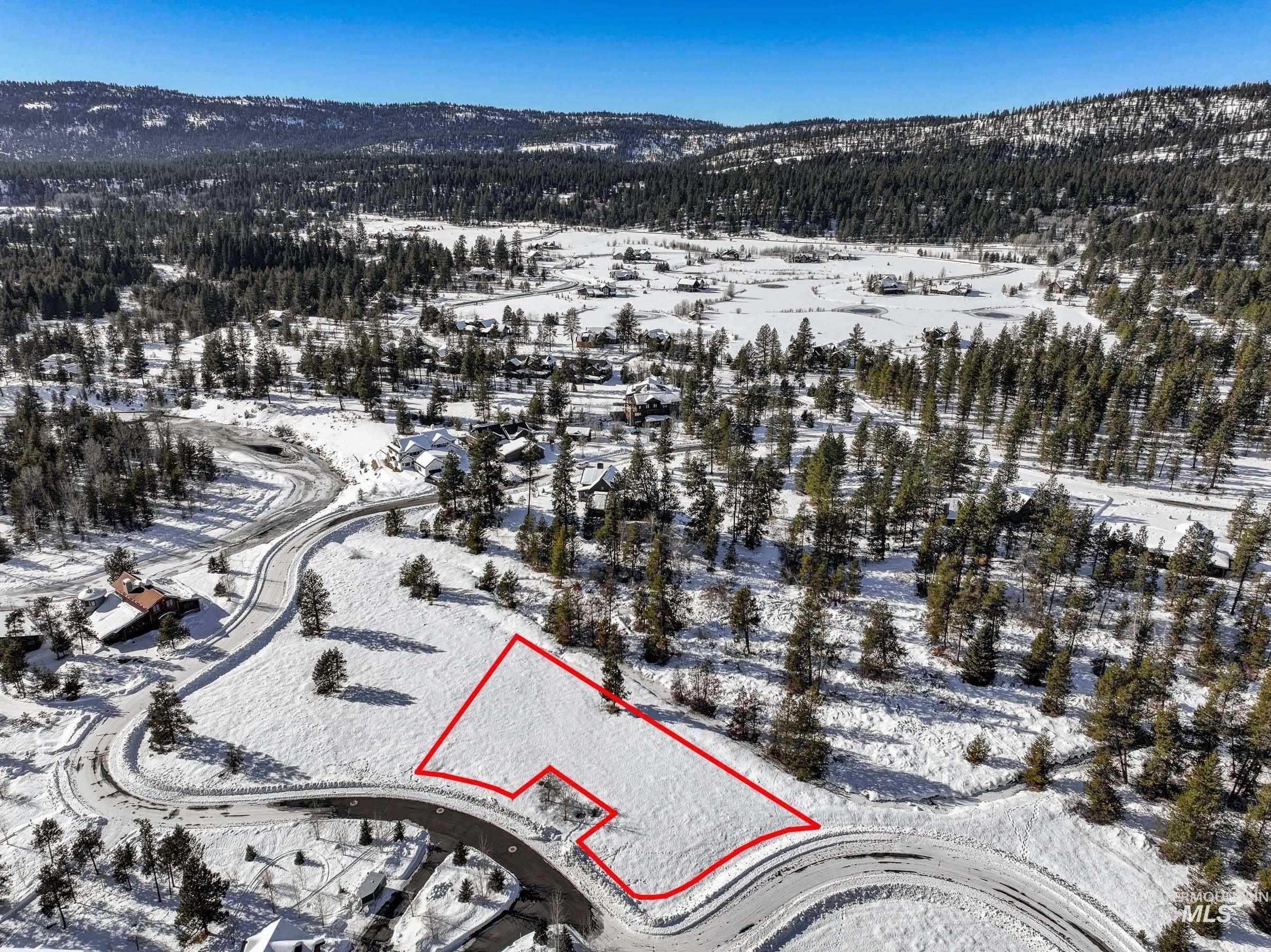 Snowy aerial view featuring property boundaries highlighted and a mountain view