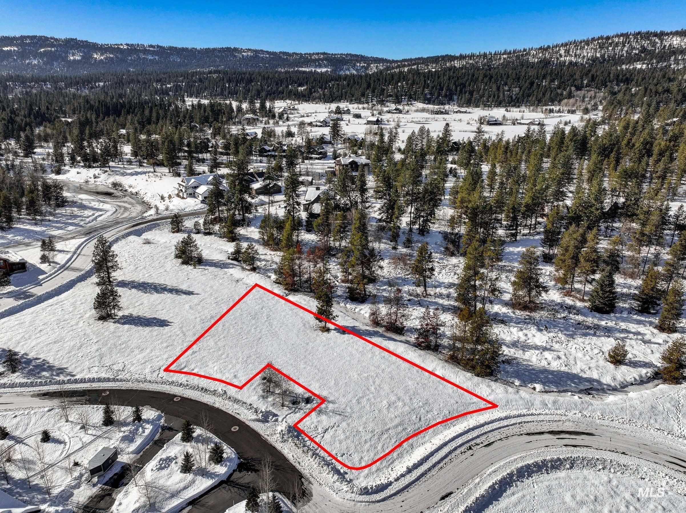 Snowy aerial view with property parcel outlined and a mountain view