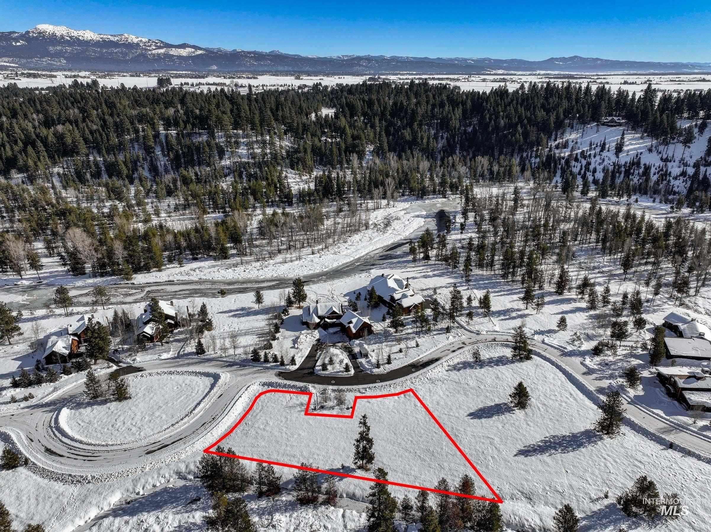 Snowy aerial view with property parcel outlined and a mountain view