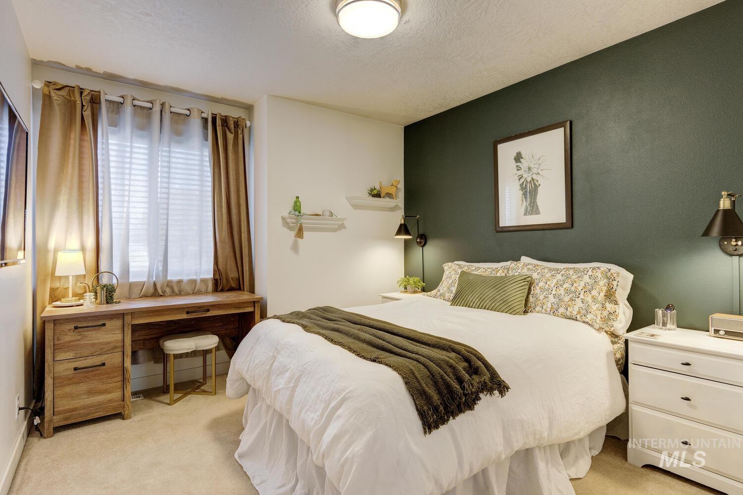 Bedroom with light carpet and a textured ceiling