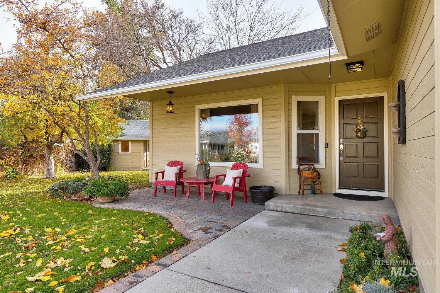 Entrance to property featuring a shingled roof, a yard, and covered porch