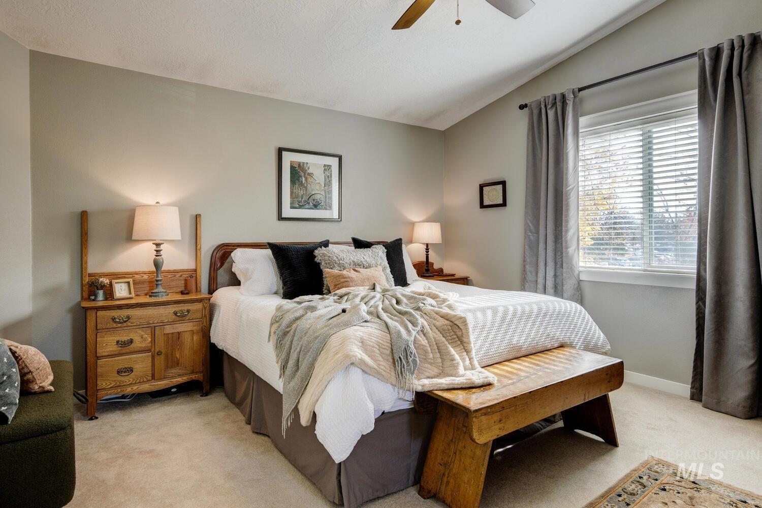 Bedroom with light carpet, lofted ceiling, and ceiling fan